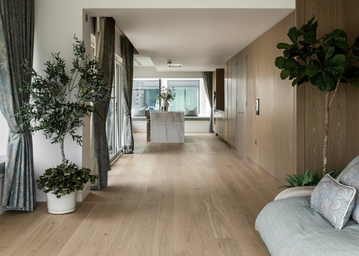 plank wood flooring in large open plan living space with a seating area flowing down to a kitchen with an island