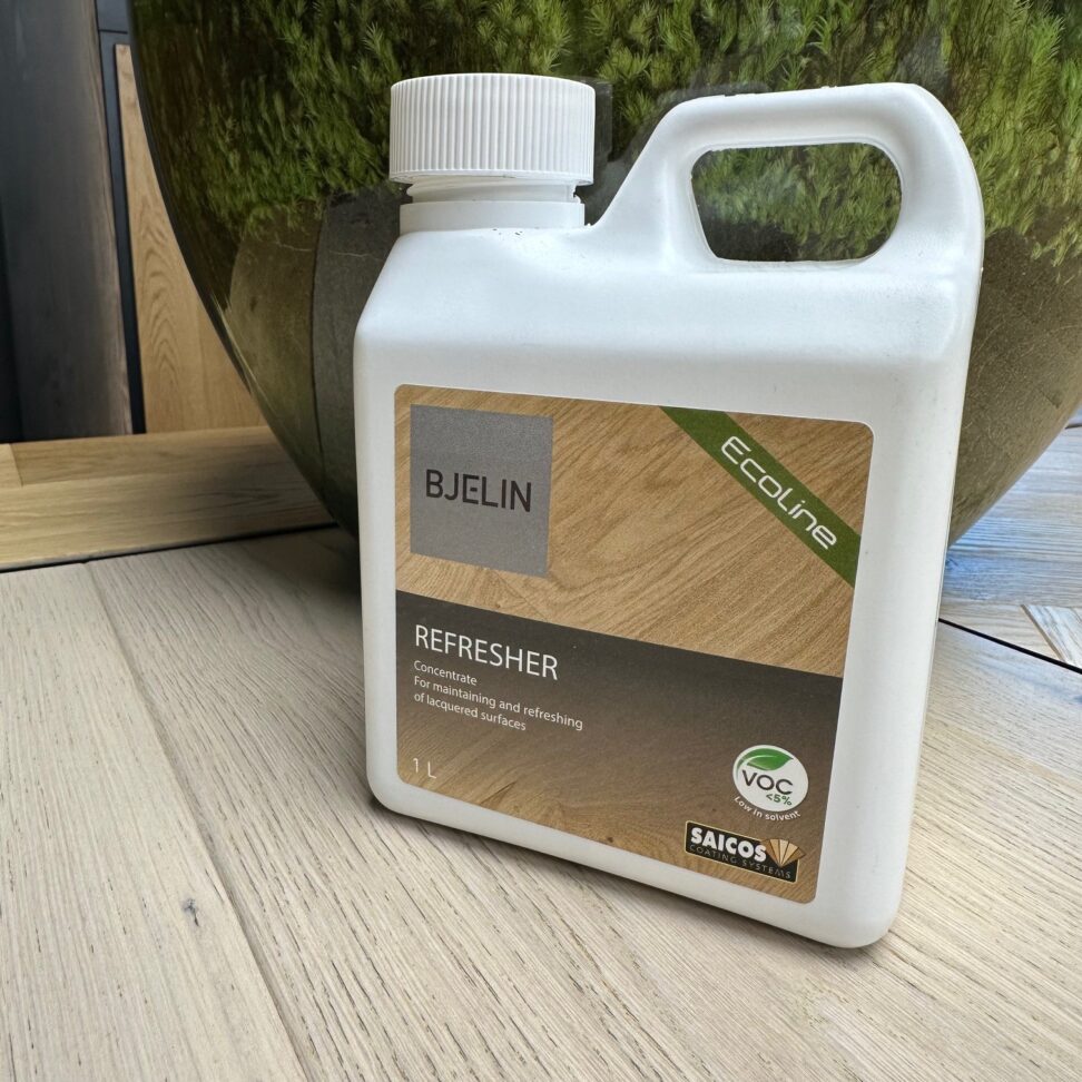 Bjelin Ecoline refresher bottle on a wooden surface with a green plant in the background