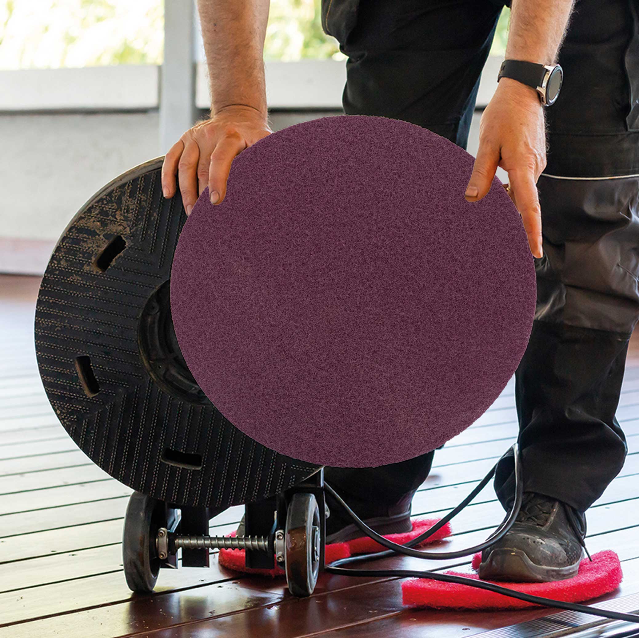 A person using the rubio purple buffing pad on a wood floor