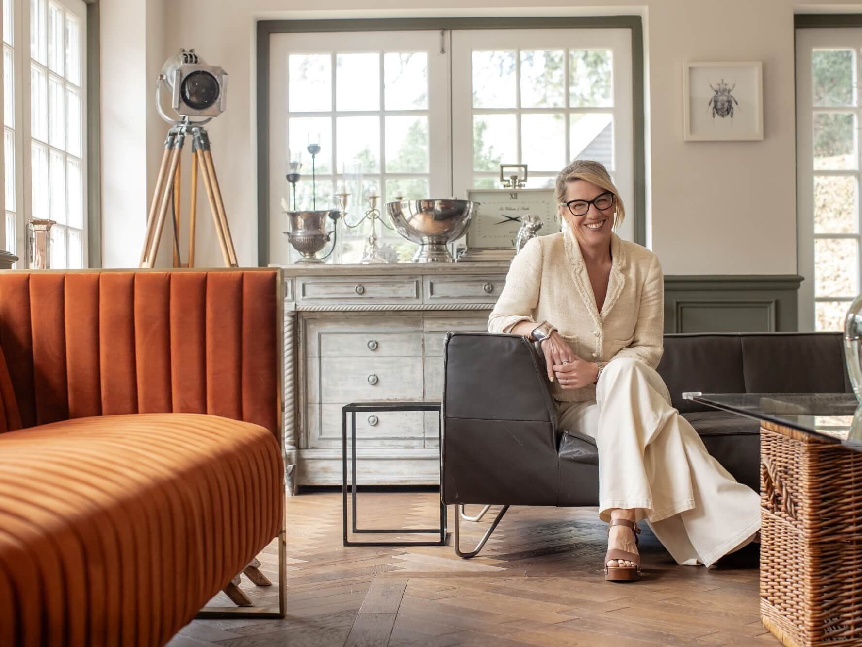 an interior designer sitting on a sofa in a room she designed with v4 wood floors
