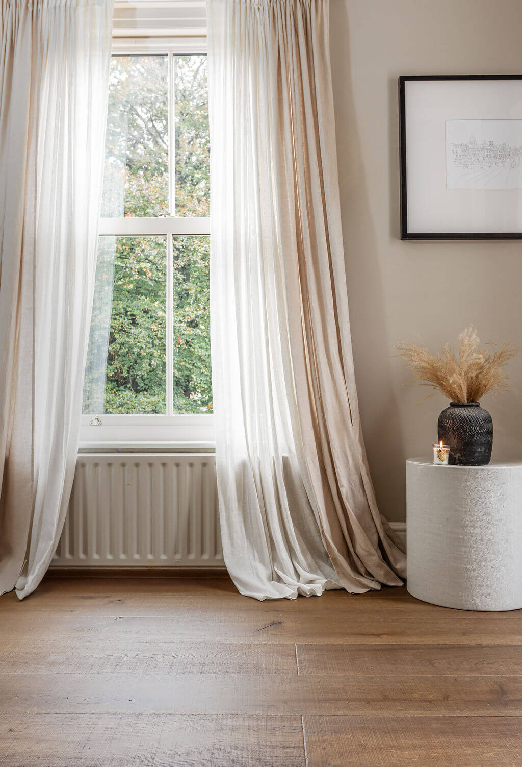 urban nature engineered wood floor planks by a window with long flowing curtains