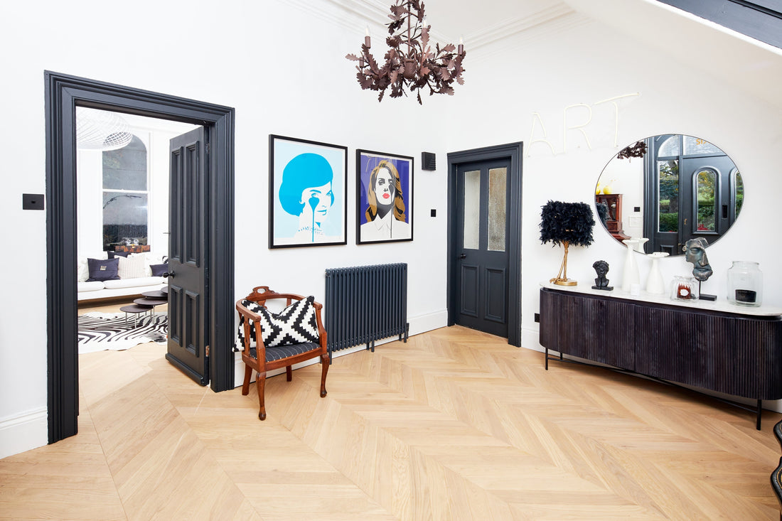 Bright hallway with white walls and dark blue wood work and seashell chevron wood floors