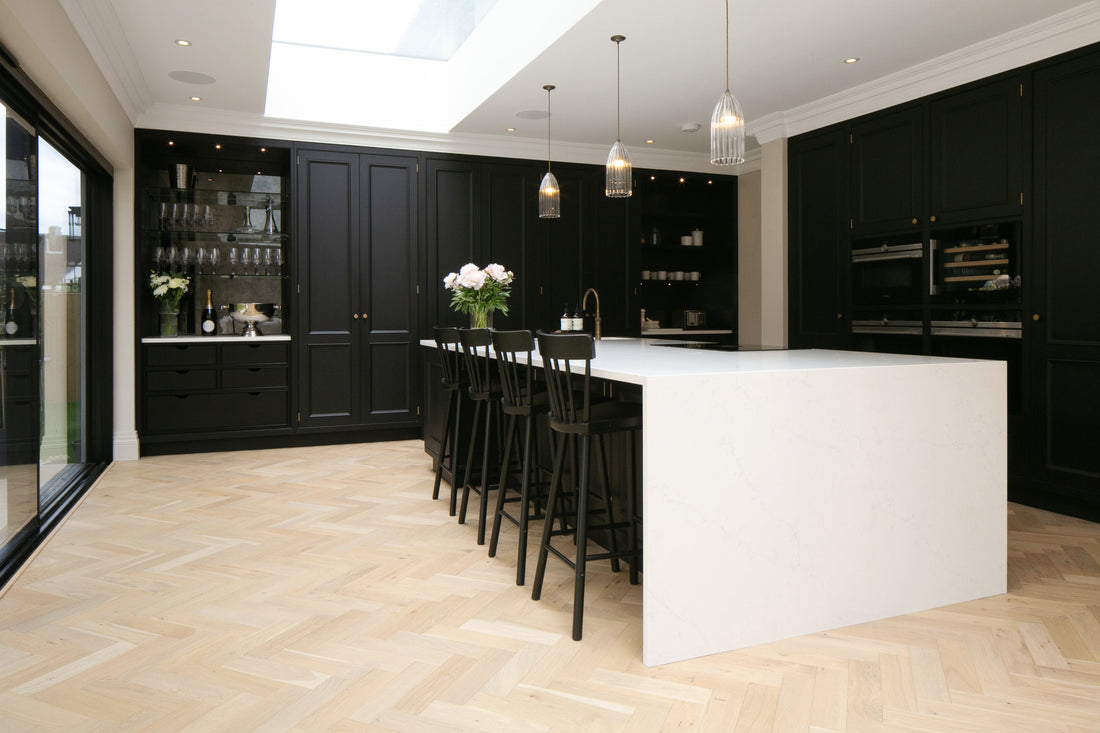 dark blue cabinets in kitchen with white island and shore drift oak herringbone oak floors