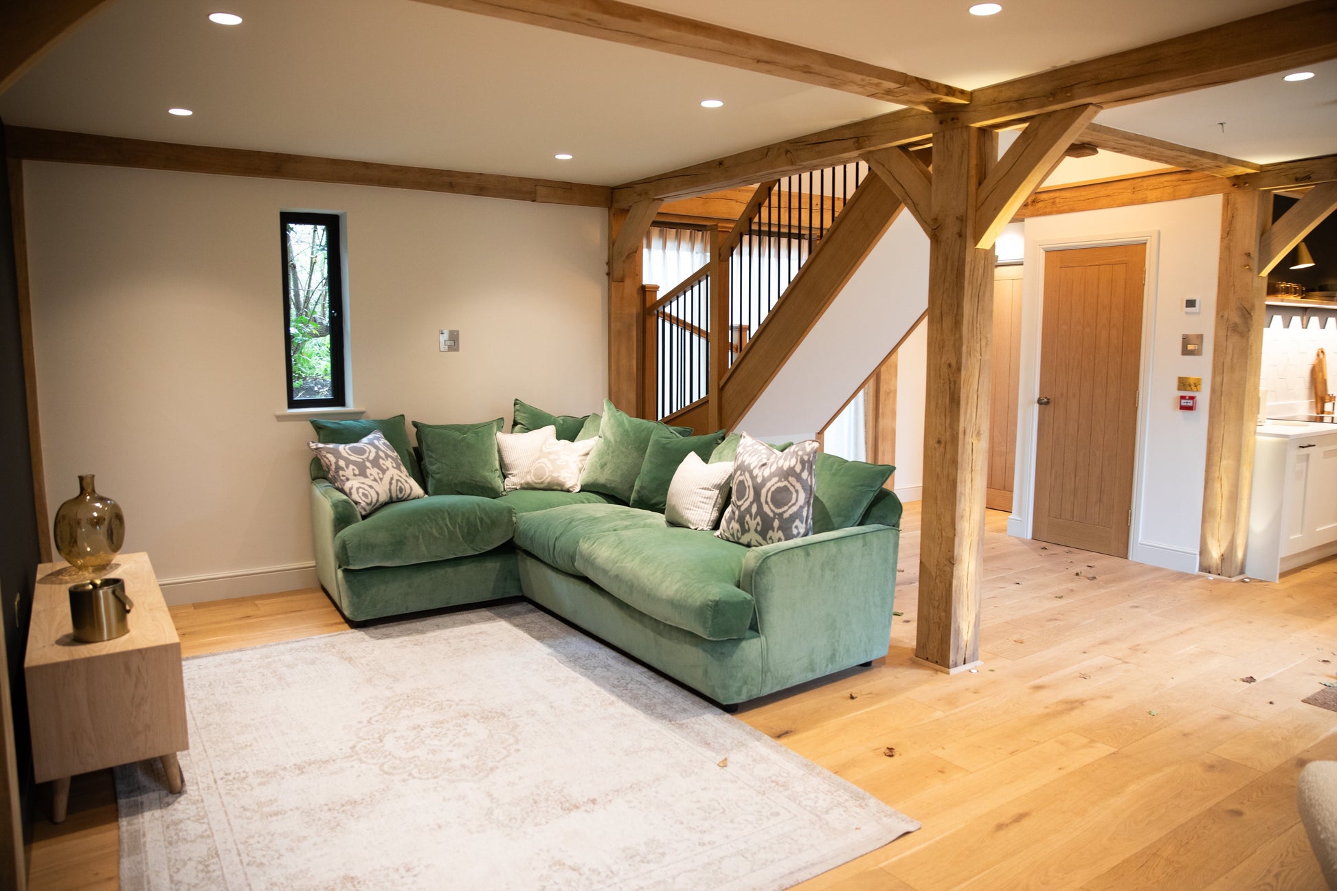 Alpine Brushed Oak floors in a living room with wood beams and a green sofa