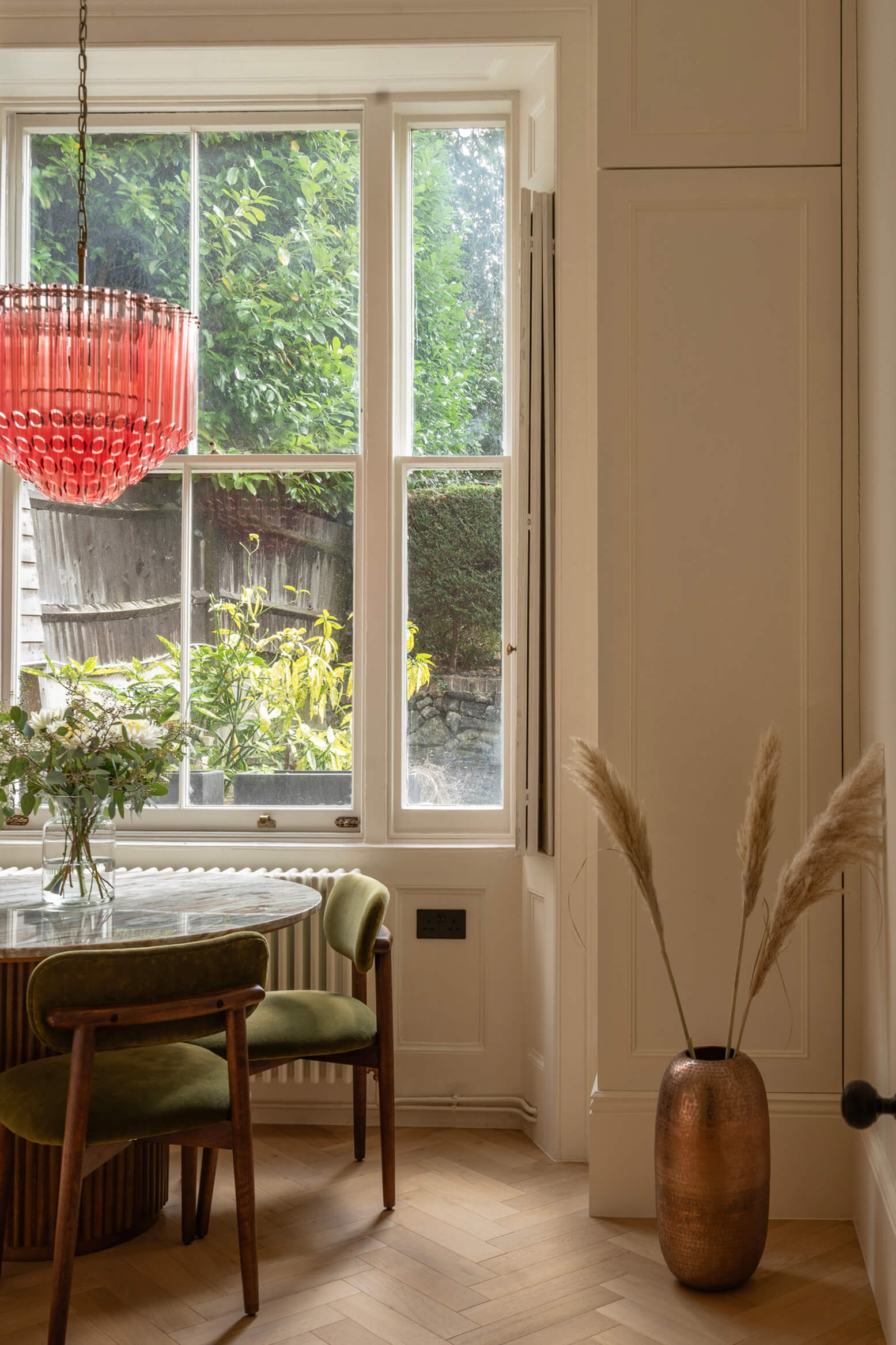 Dining space in period home with tall windows and wood floors