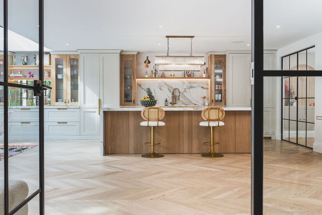 Modern kitchen with wooden bar stools and marble countertop featuring Seashelll chevron floors