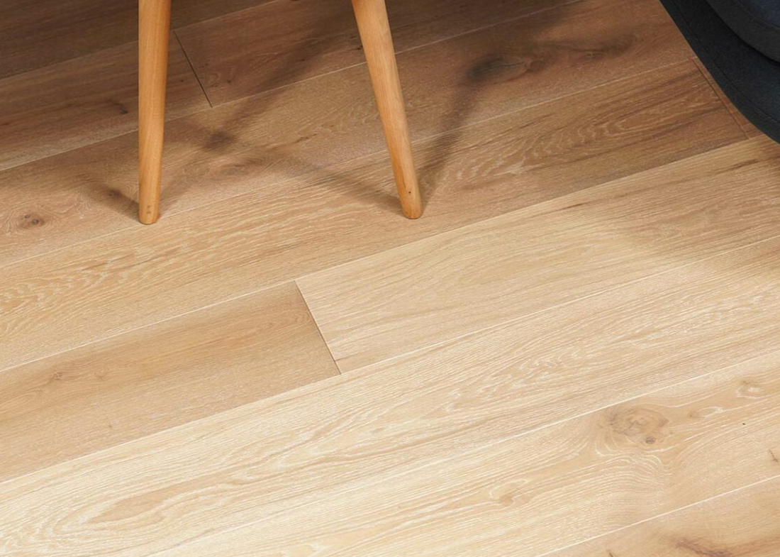 Close-up of wooden flooring with a chair leg visible