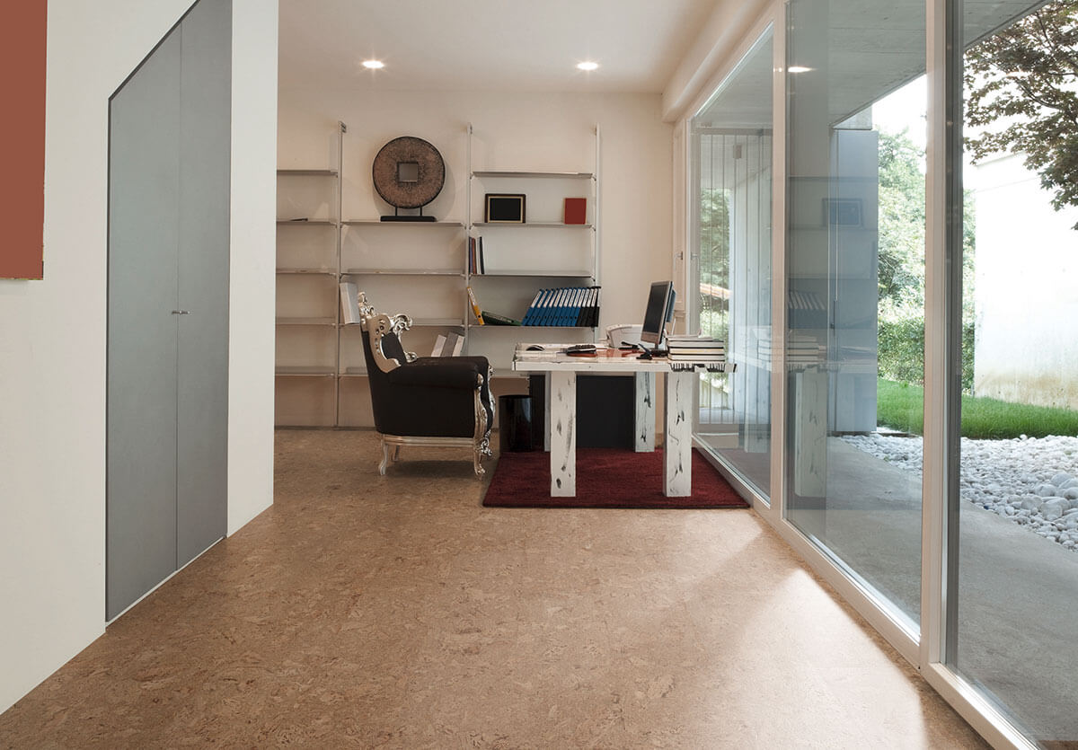Home office with dark brown cork floors, overlooking a garden