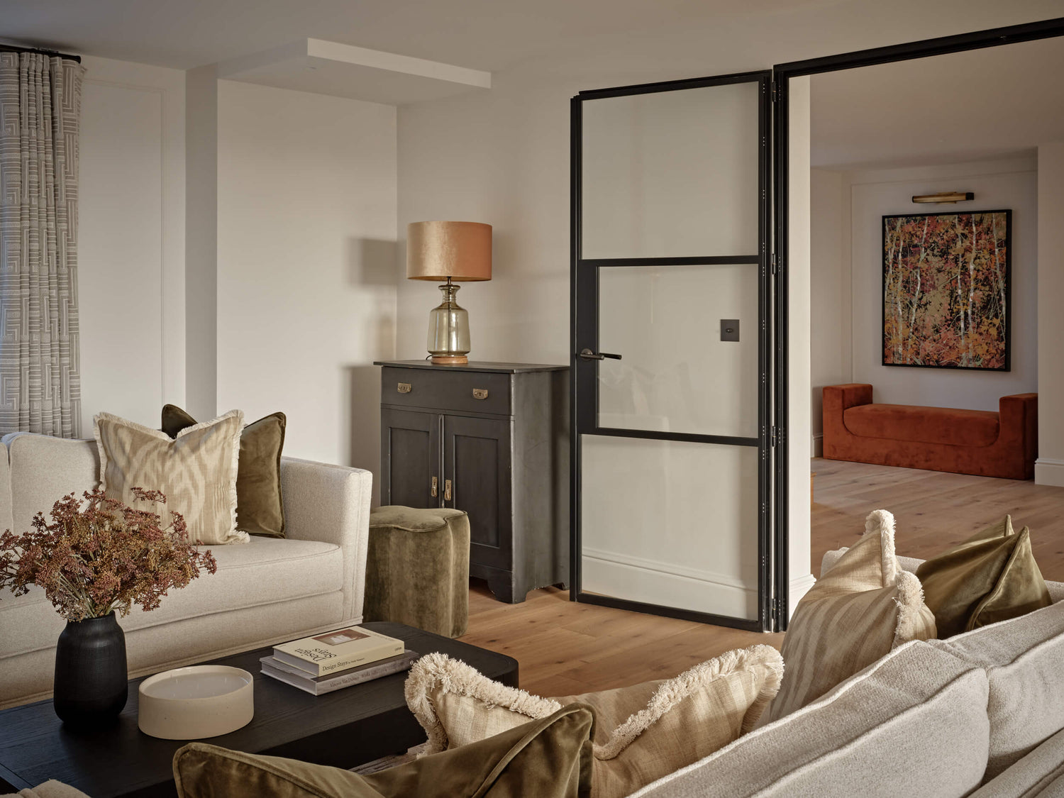 Family living room with white smoked oak wood floors leading into the hallway with a sofa