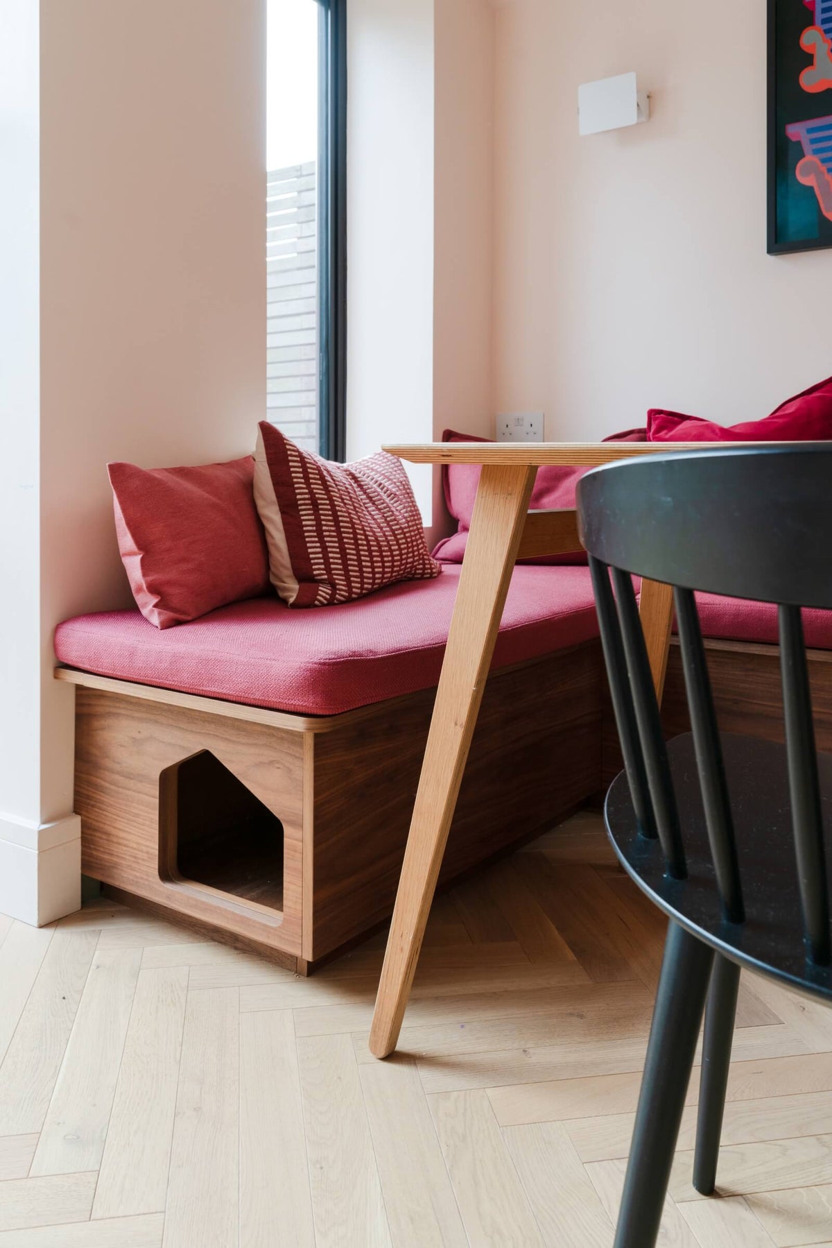 a pink banquette with cat entrance
