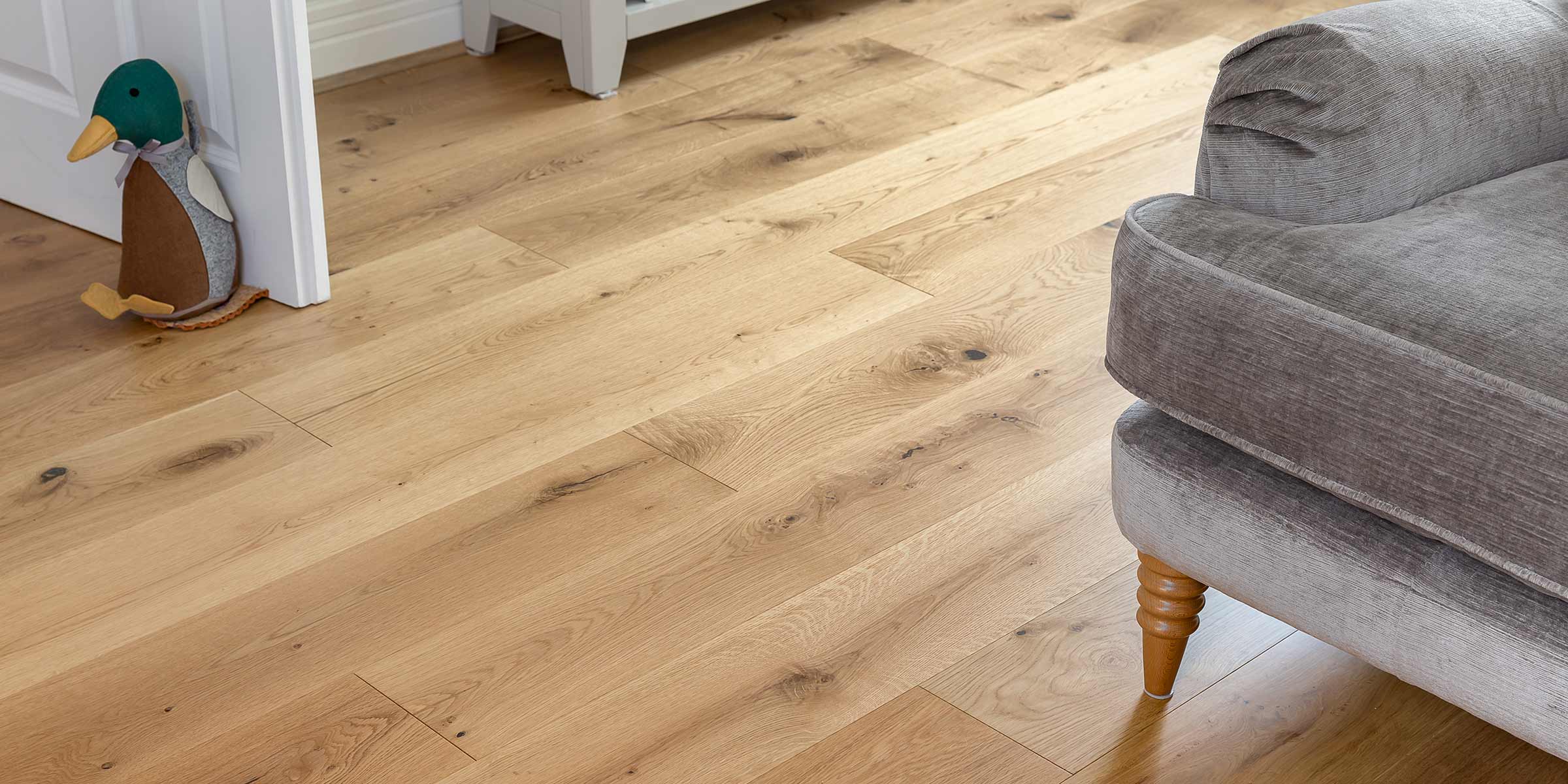 close up of alpine oak floor with duck door stop and grey chair