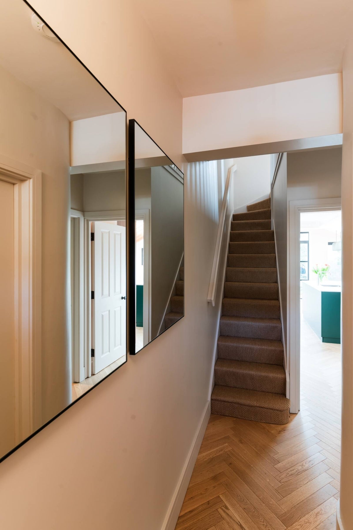 hallway with light herringbone wood floors