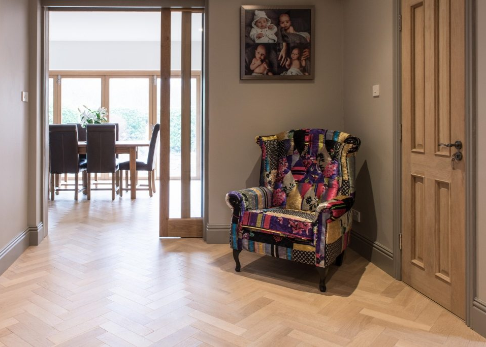 Decorative armchair with colorful patterns in a room with a door and a view of a dining area.
