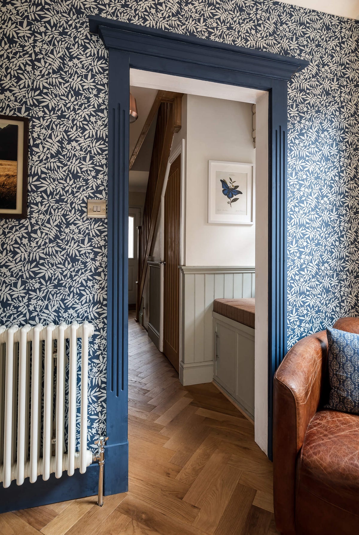 internal doorway with dark blue painted frame, blue wallpaper and smoked parquet wood floor