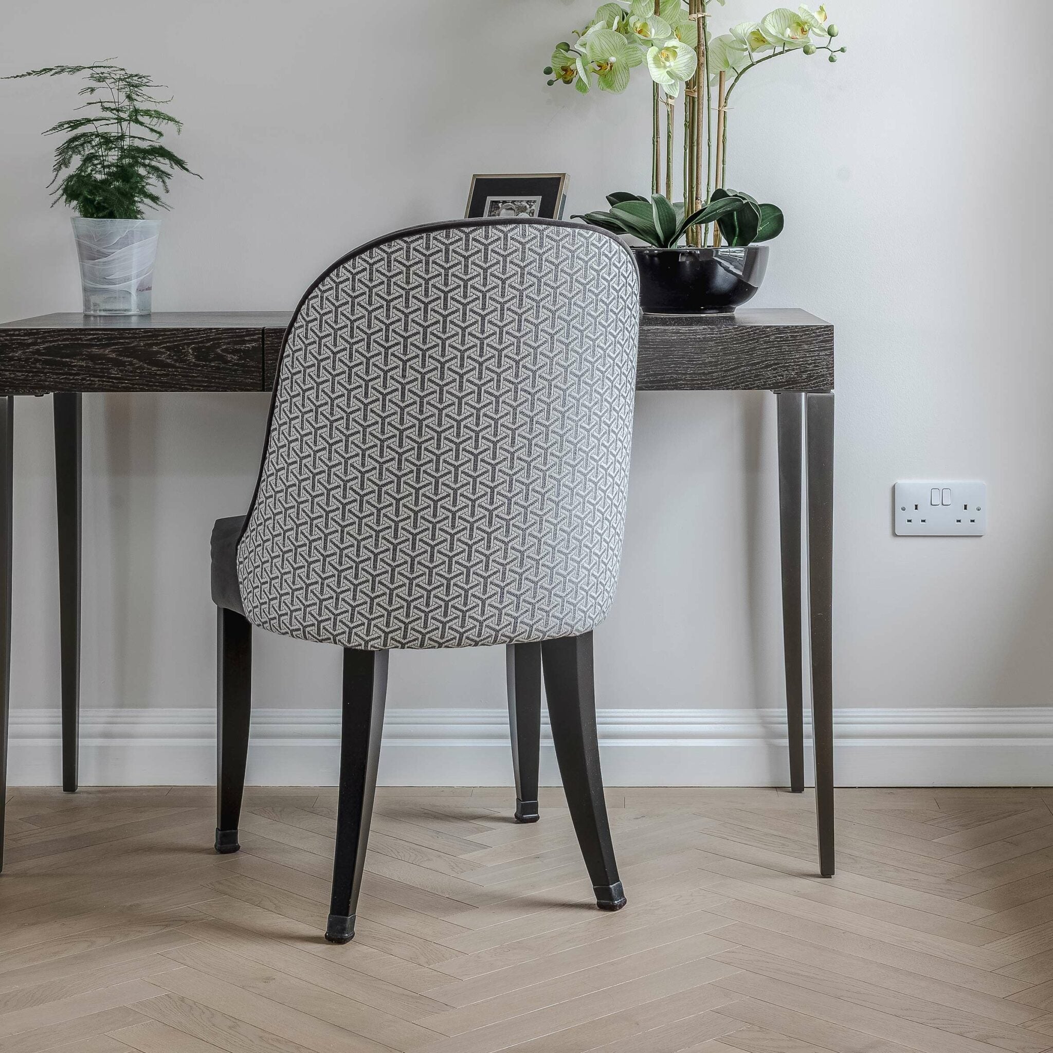 Chair with geometric pattern in a room with herringbone wood flooring