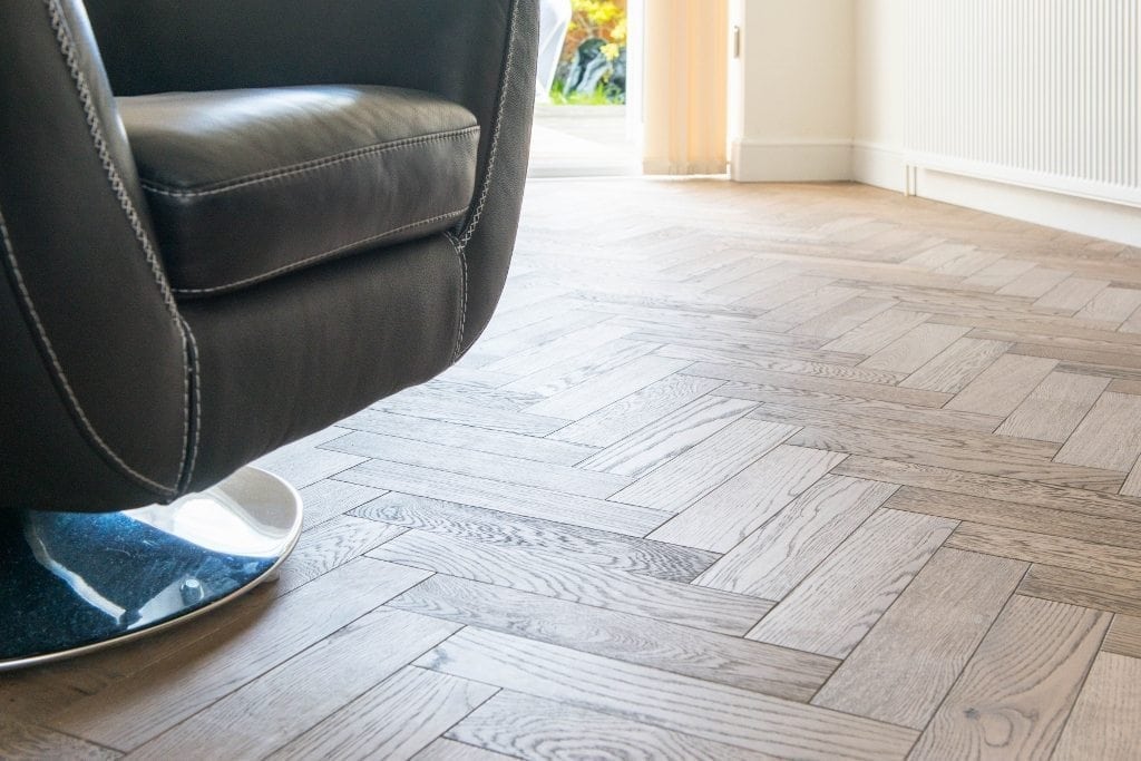 herringbone parquet flooring with a black leather chair in the foreground