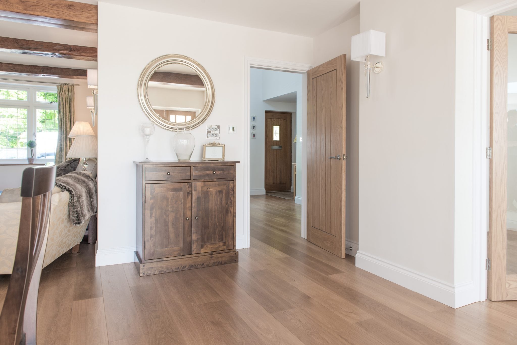 wide alpine plank wood flooring with wooden furniture and doors, exposed wood beams in the ceiling