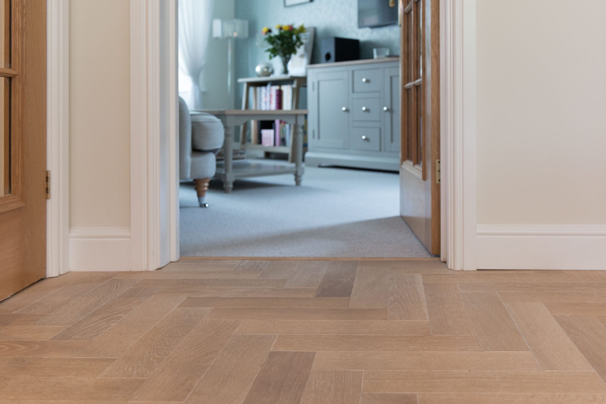 herringbone oak floors leading to a living room