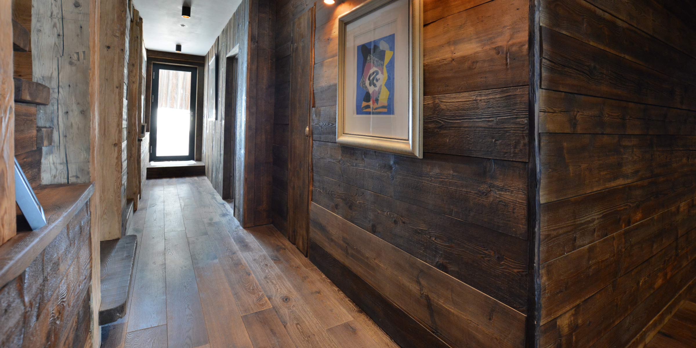 Dark wood flooring and wall panelling in a hallway