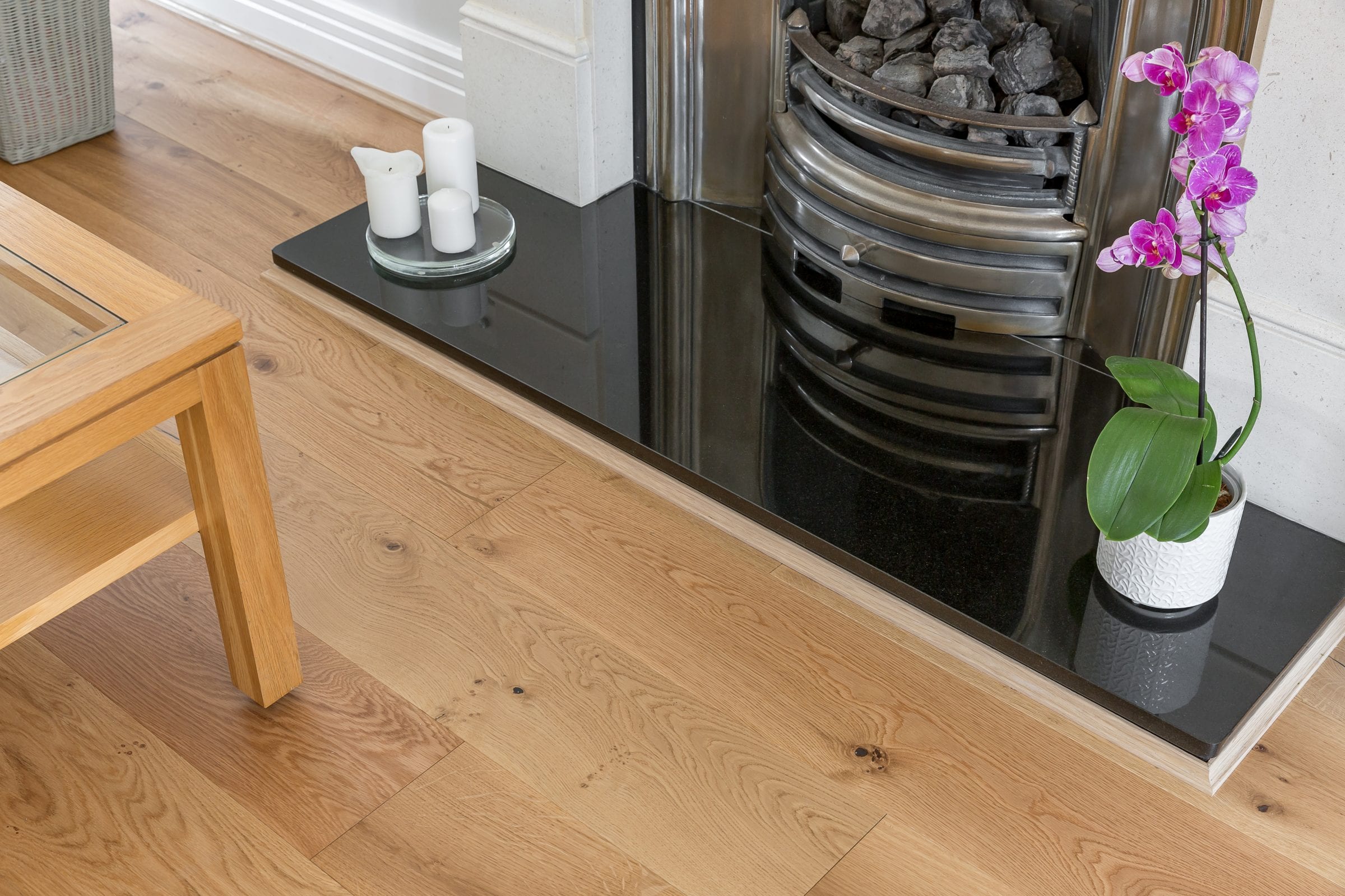 light wood floors on a fireplace hearth with a purple orchid