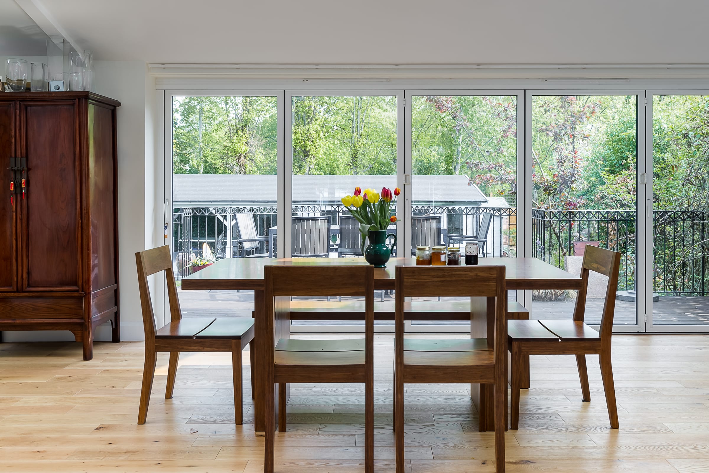 wood floors with large windows and wooden dining furniture