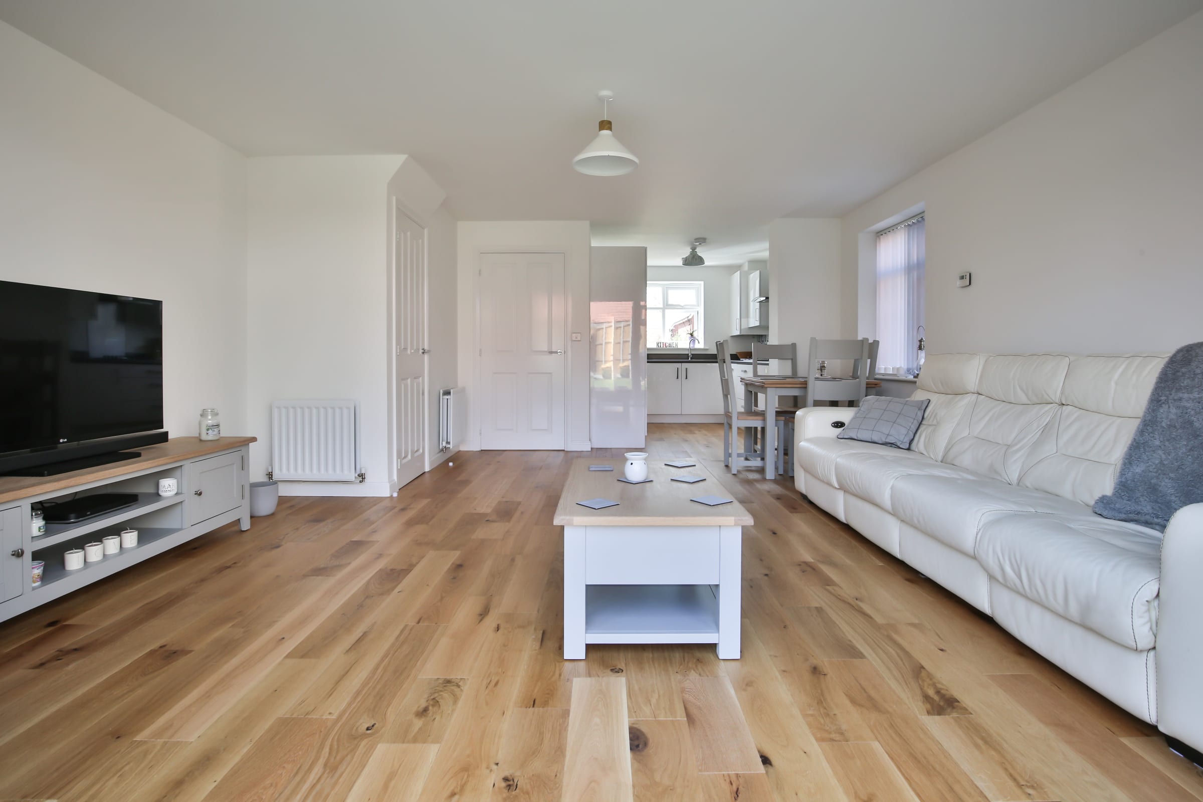 wide shot of a living room with medium toned wood flooring