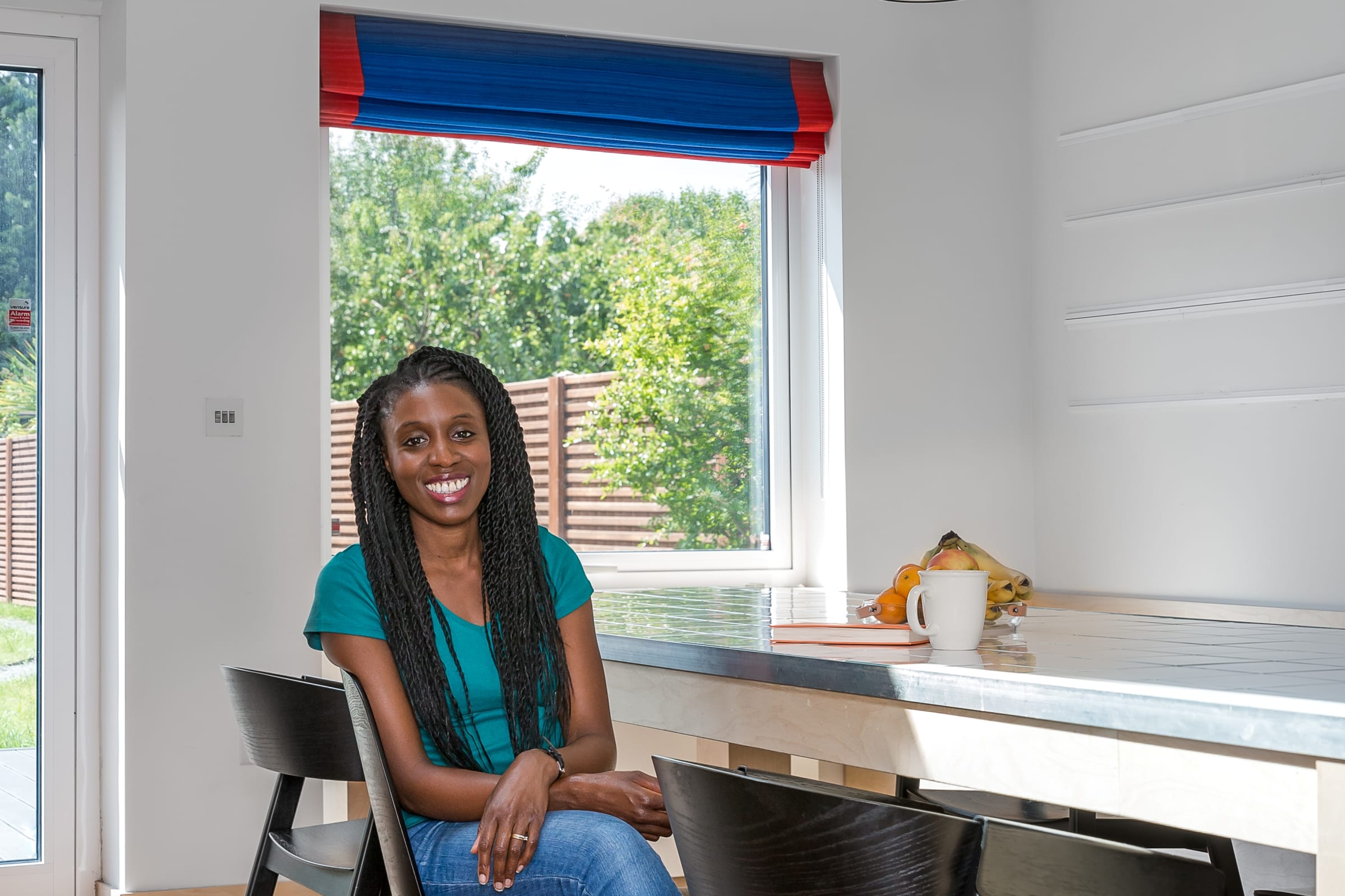 photo of the owner of the house, smiling sitting at the dining room table