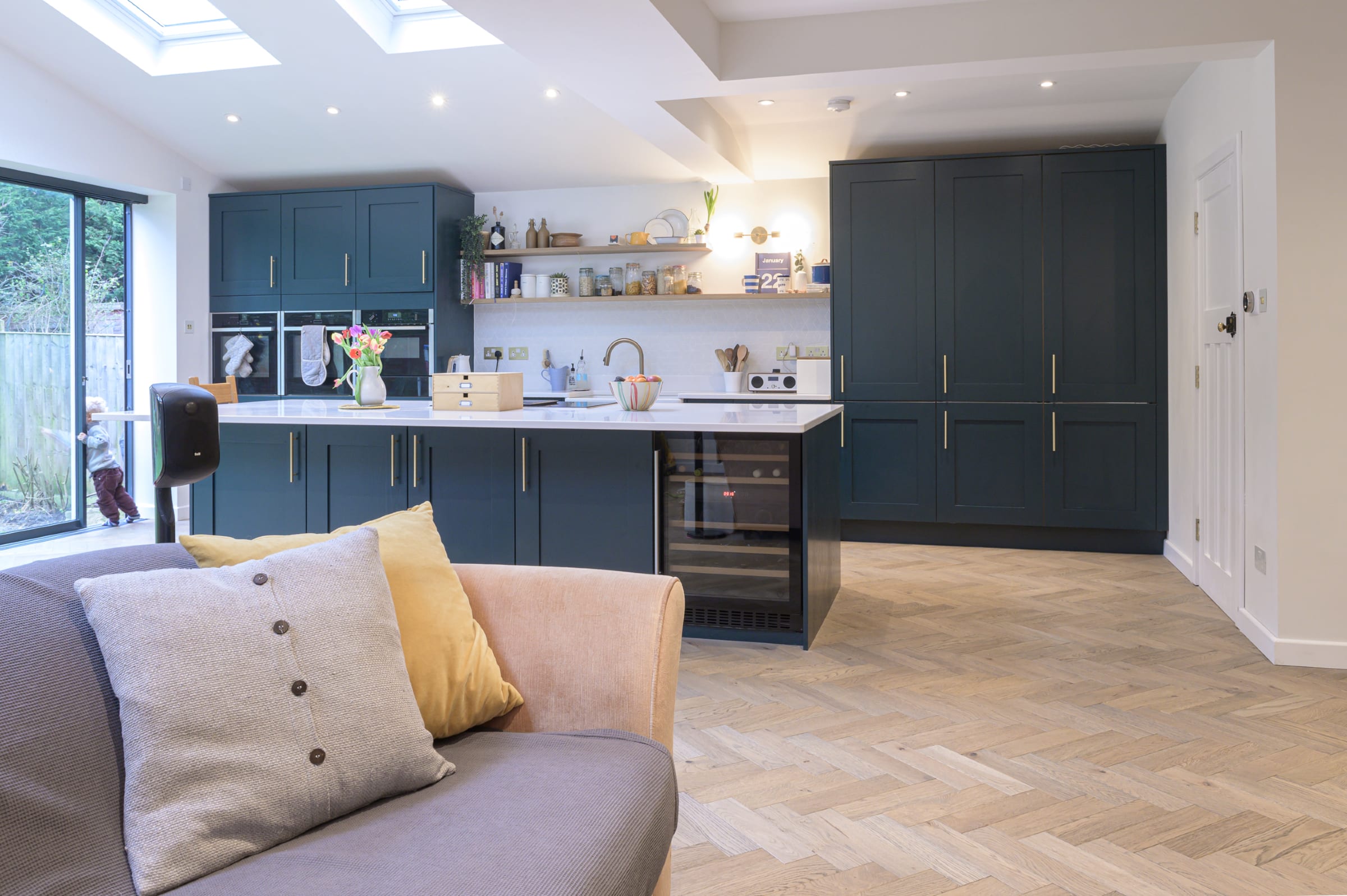 blue kitchen with herringbone wood floors