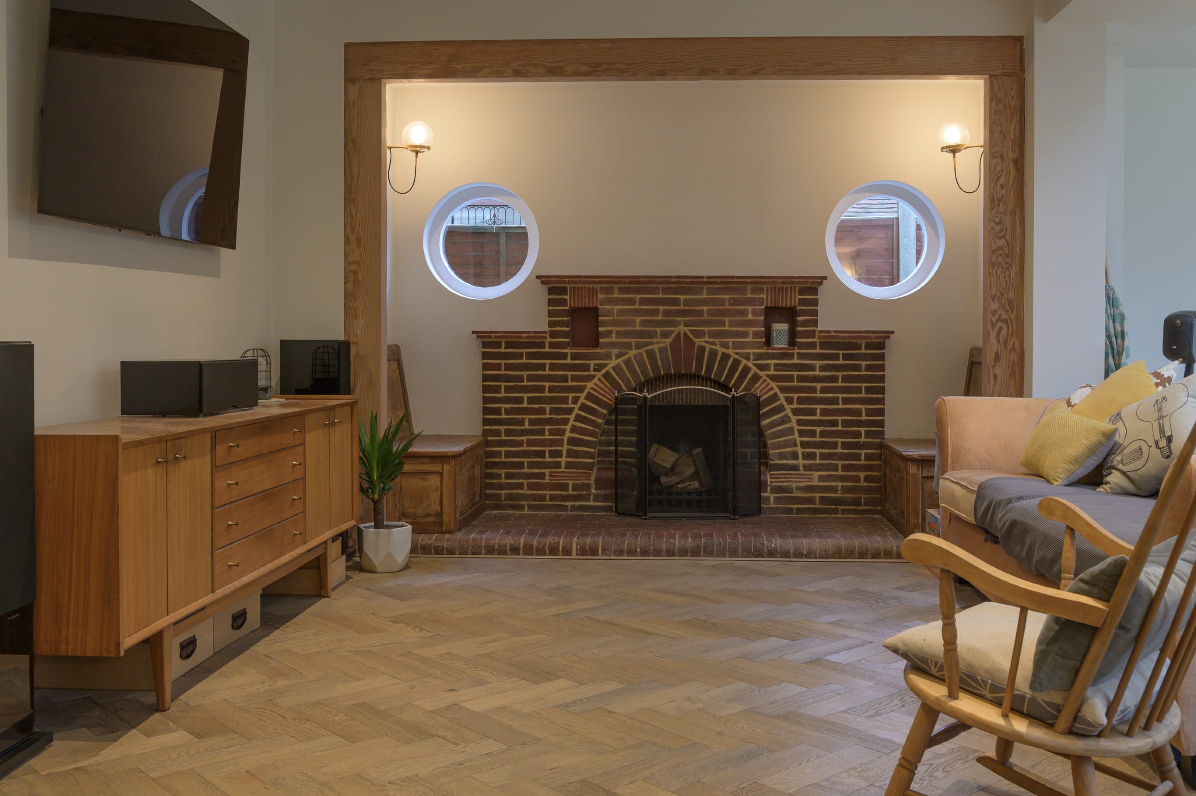 brick fireplace and herringbone wood floors