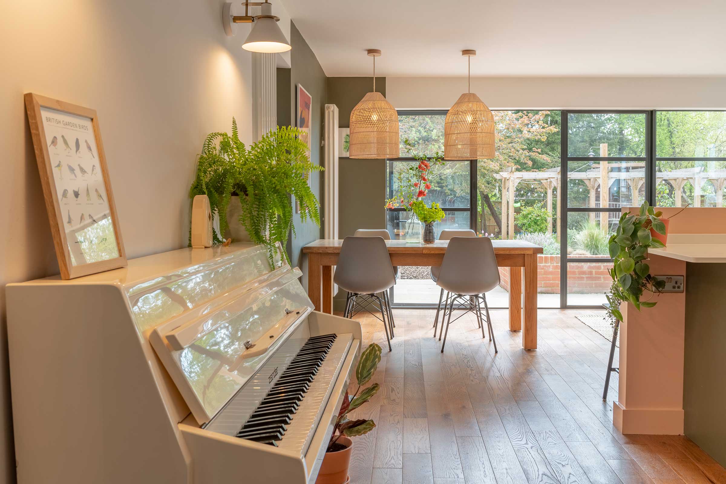 white upright piano in an open plan dining room / living room