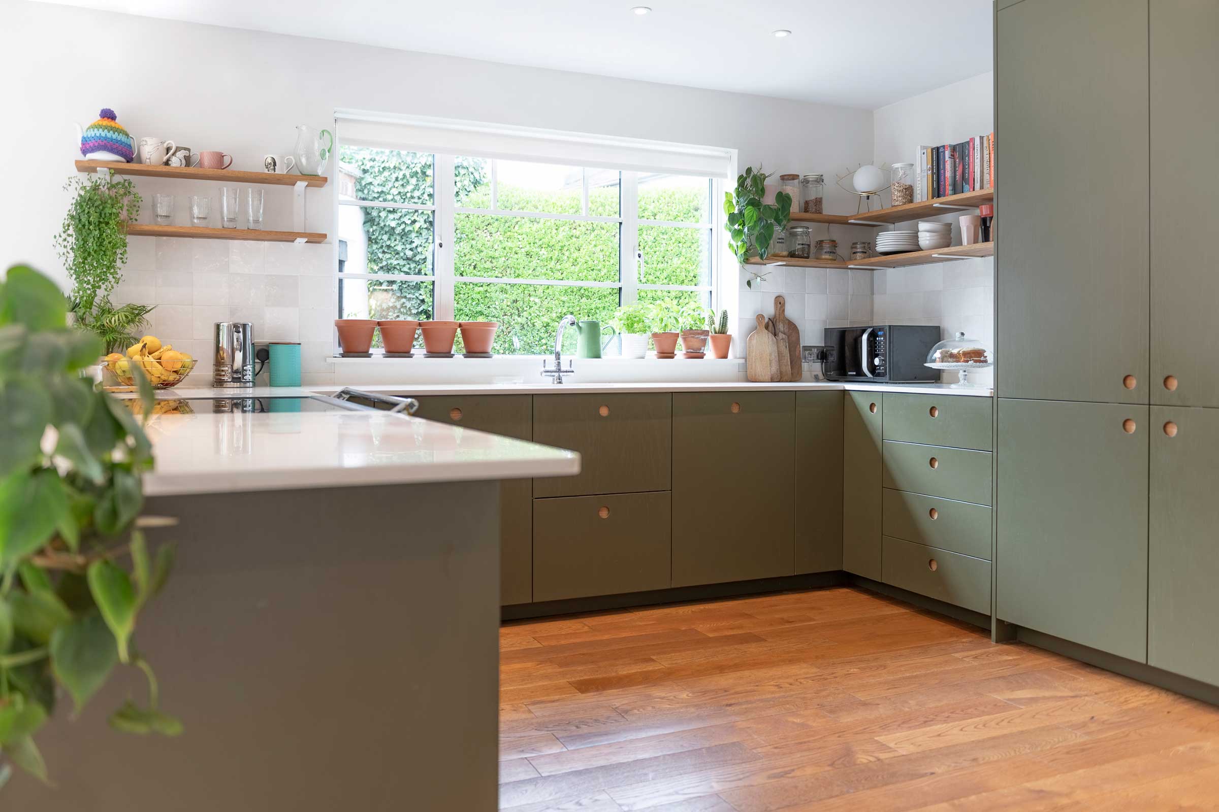 wood floors in a modern kitchen with green cabinets