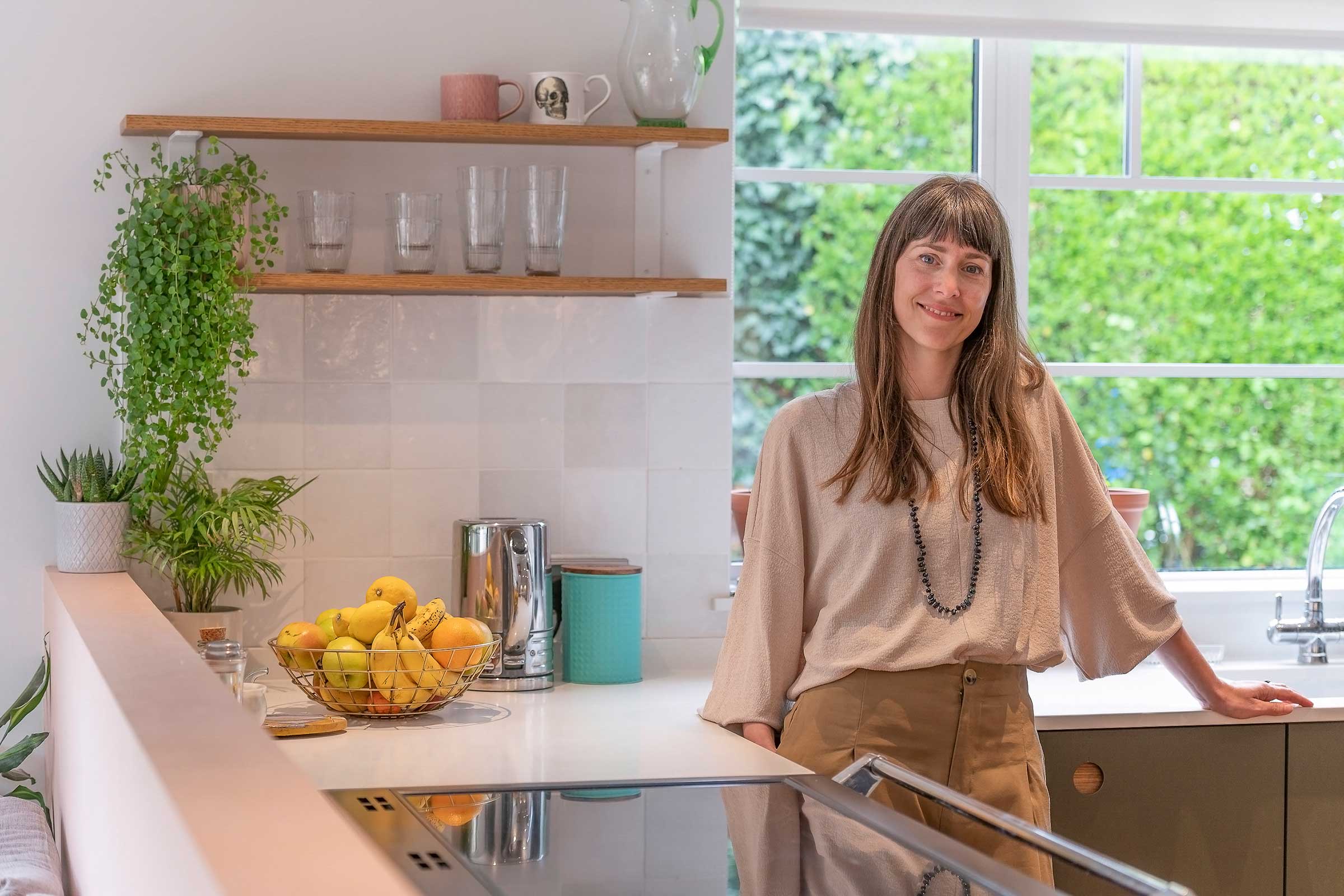 Smiling woman standing in a modern refurbished kitchen