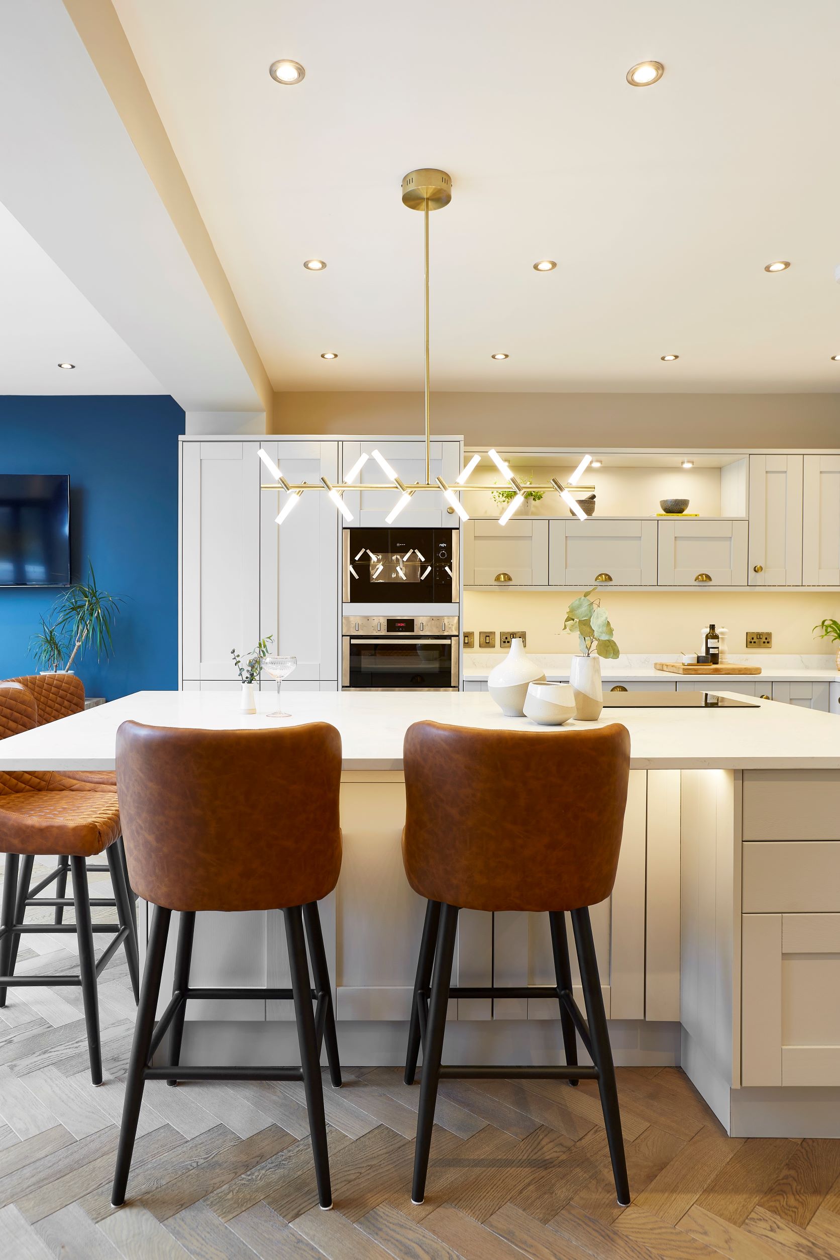 Herringbone oak wood floors in a modern white kitchen