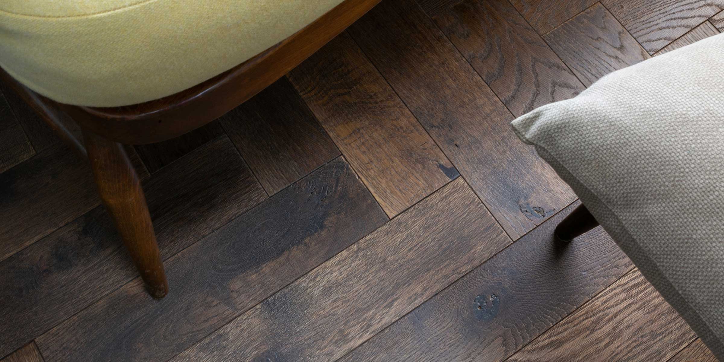 Engineered dark wooden flooring with a small stool on the right and seat on the left