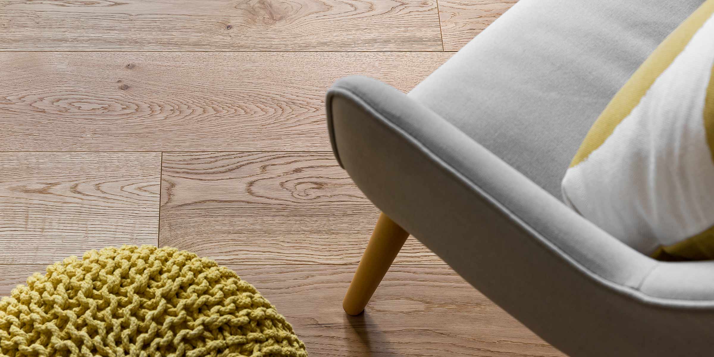 beautiful light oak plank flooring with a light grey chair in the foreground