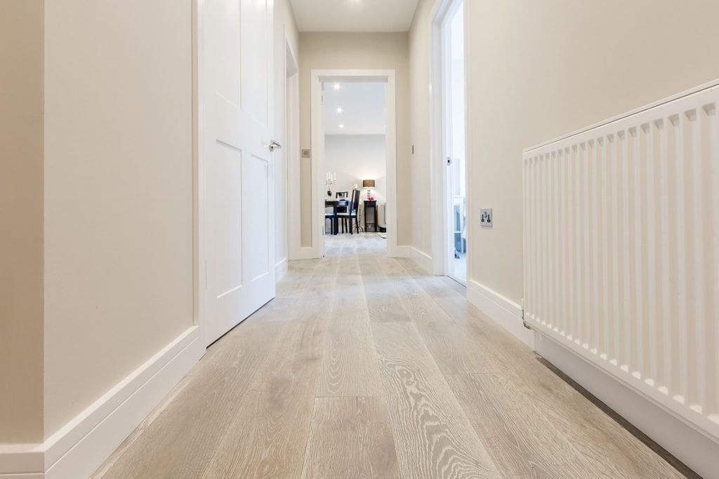 a light oak wood floor in a hallway, silvery accents