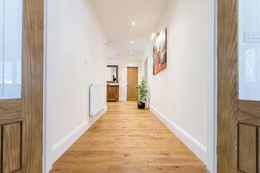 golden stained oak wood floor in a long hallway