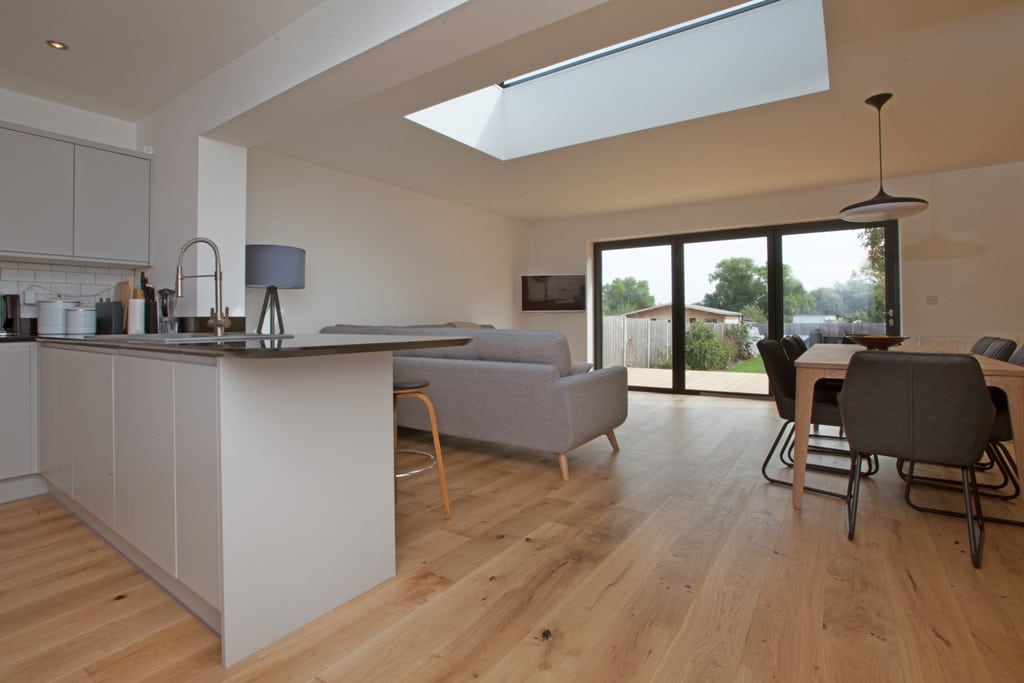 view from a kitchen of an open plan kitchen and living room with oak wood floors