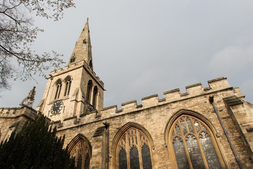 looking up at a church steeple and vestry windows