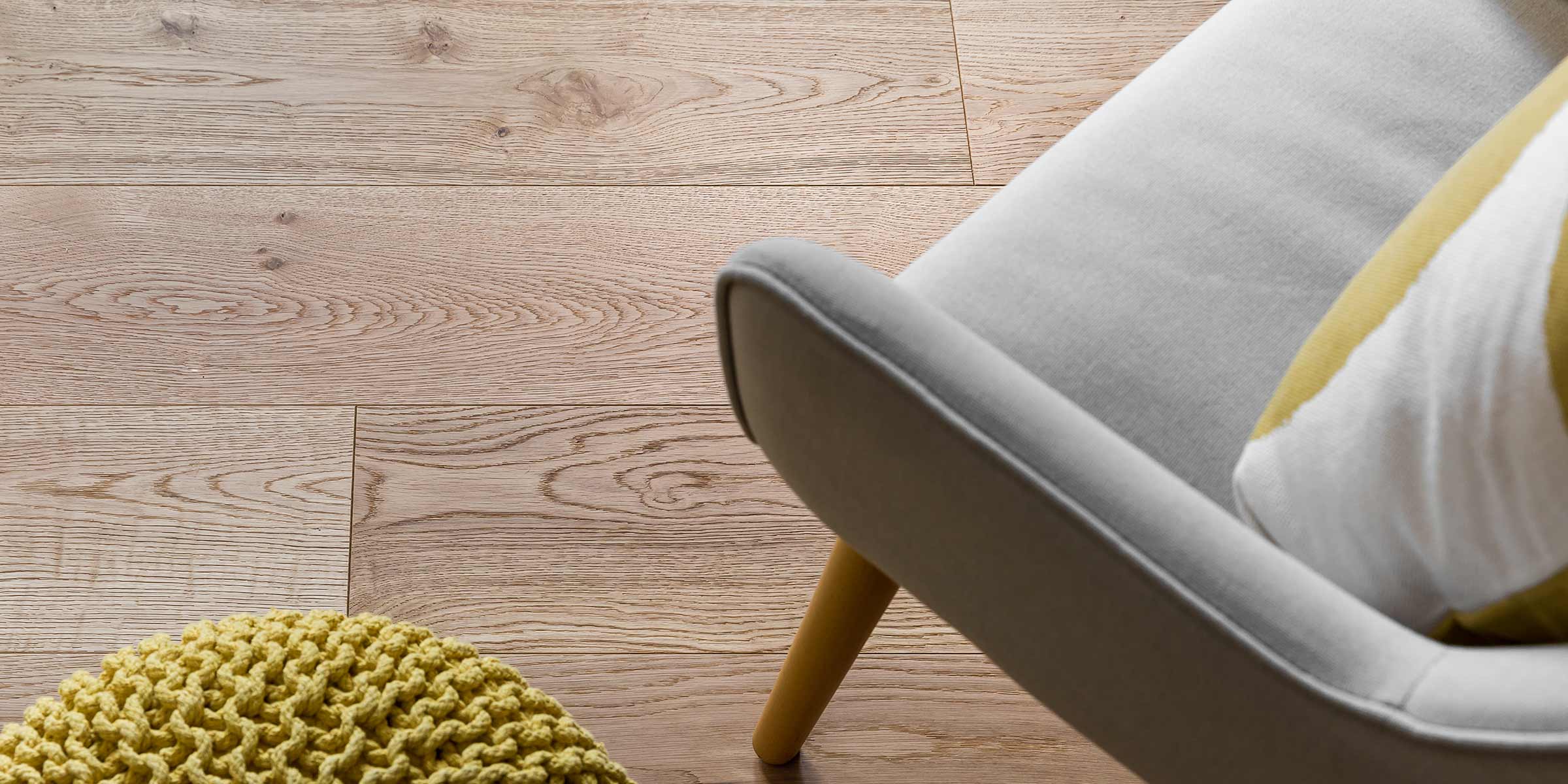 close up of oak wood floors with a grey chair