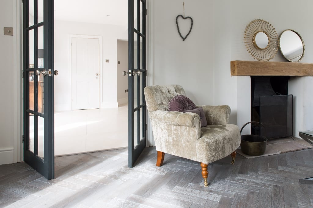 light and airy room with french doors and light grey herringbone wood flooring