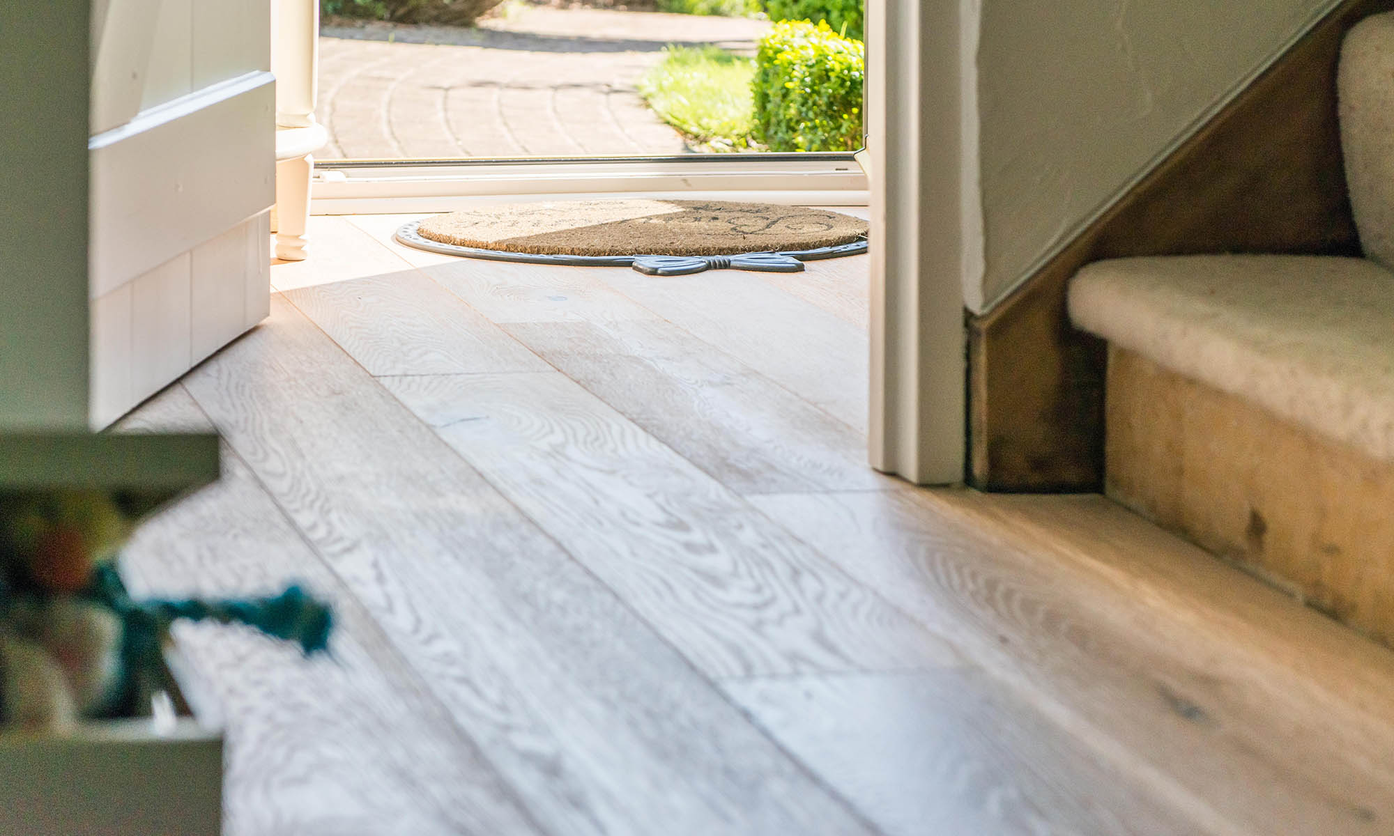 beautiful natural oak wood floors leading to an open door and front porch