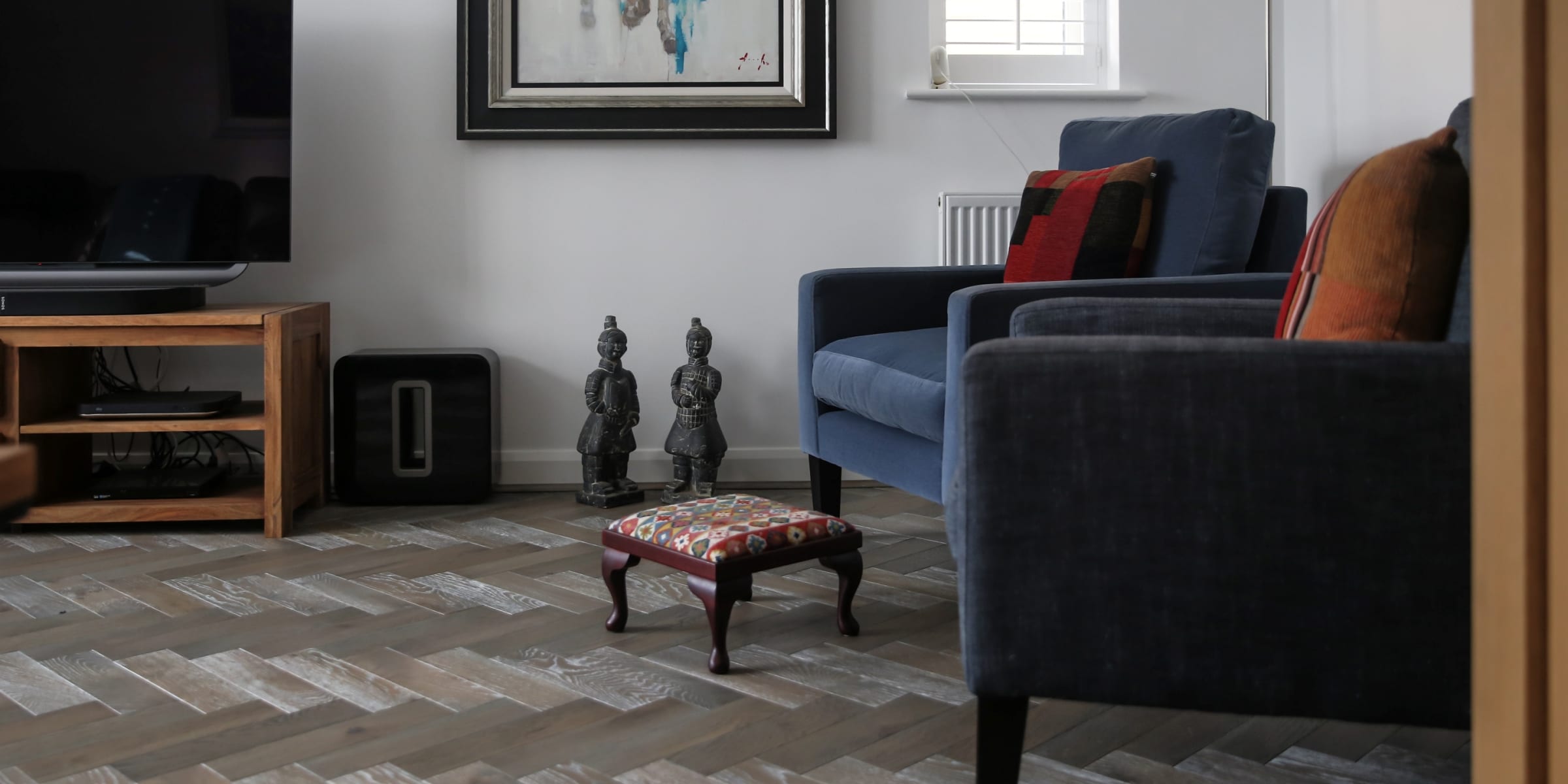 zig zag herringbone wood floors with a footstool