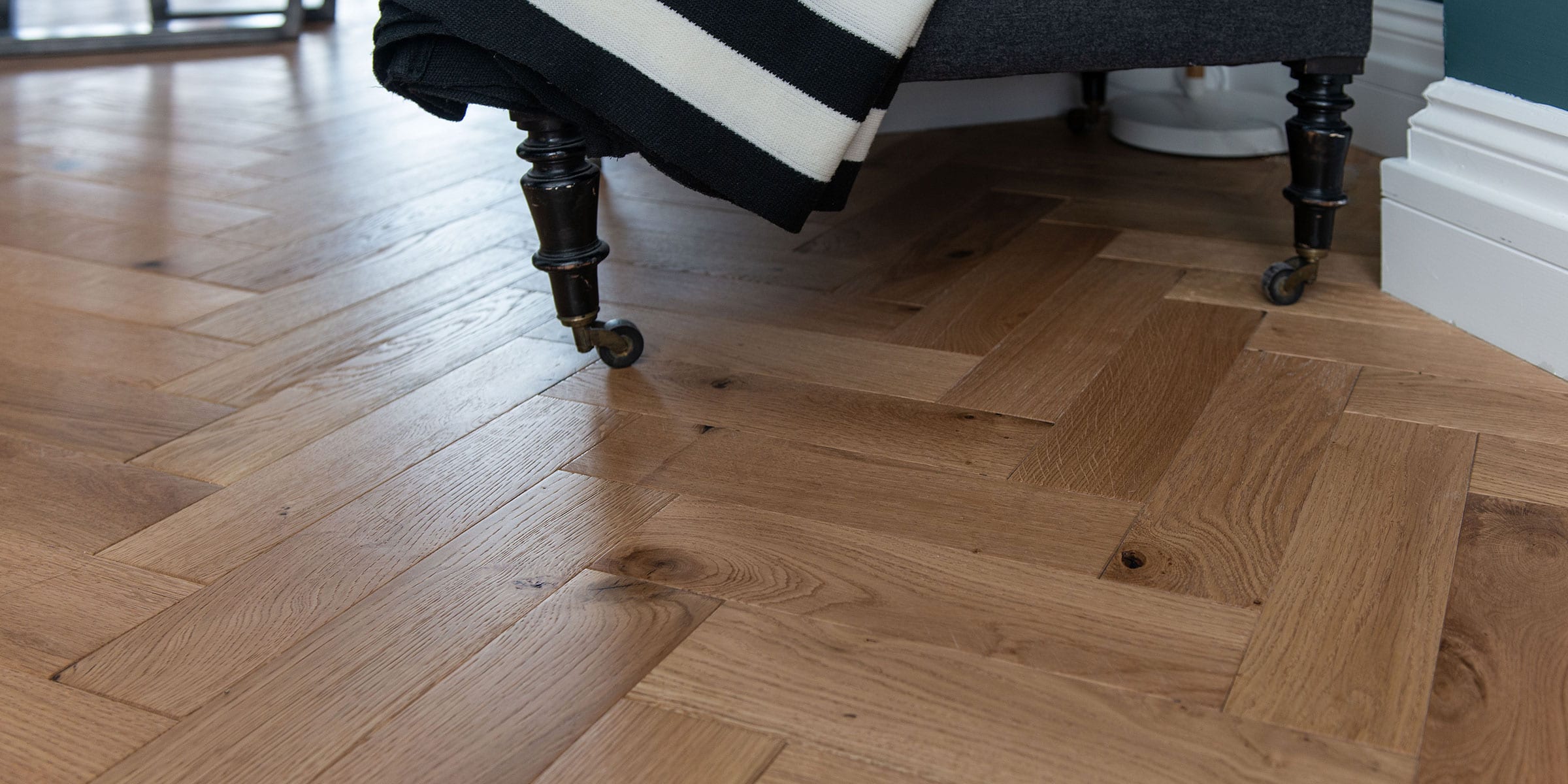 close up of herringbone wood flooring with a black and white blanket