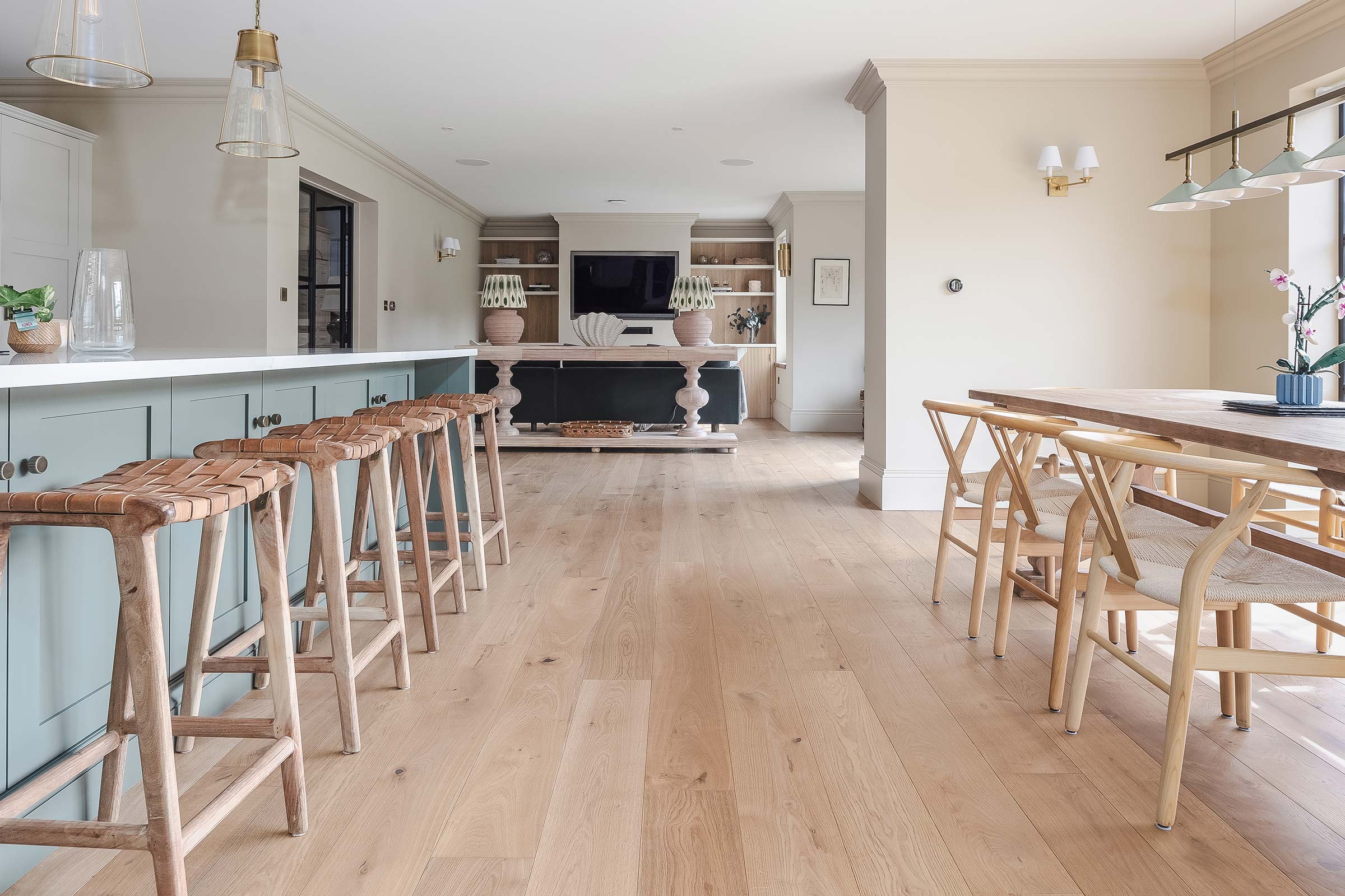 light oak wood floors in a modern kitchen with teal cupboards