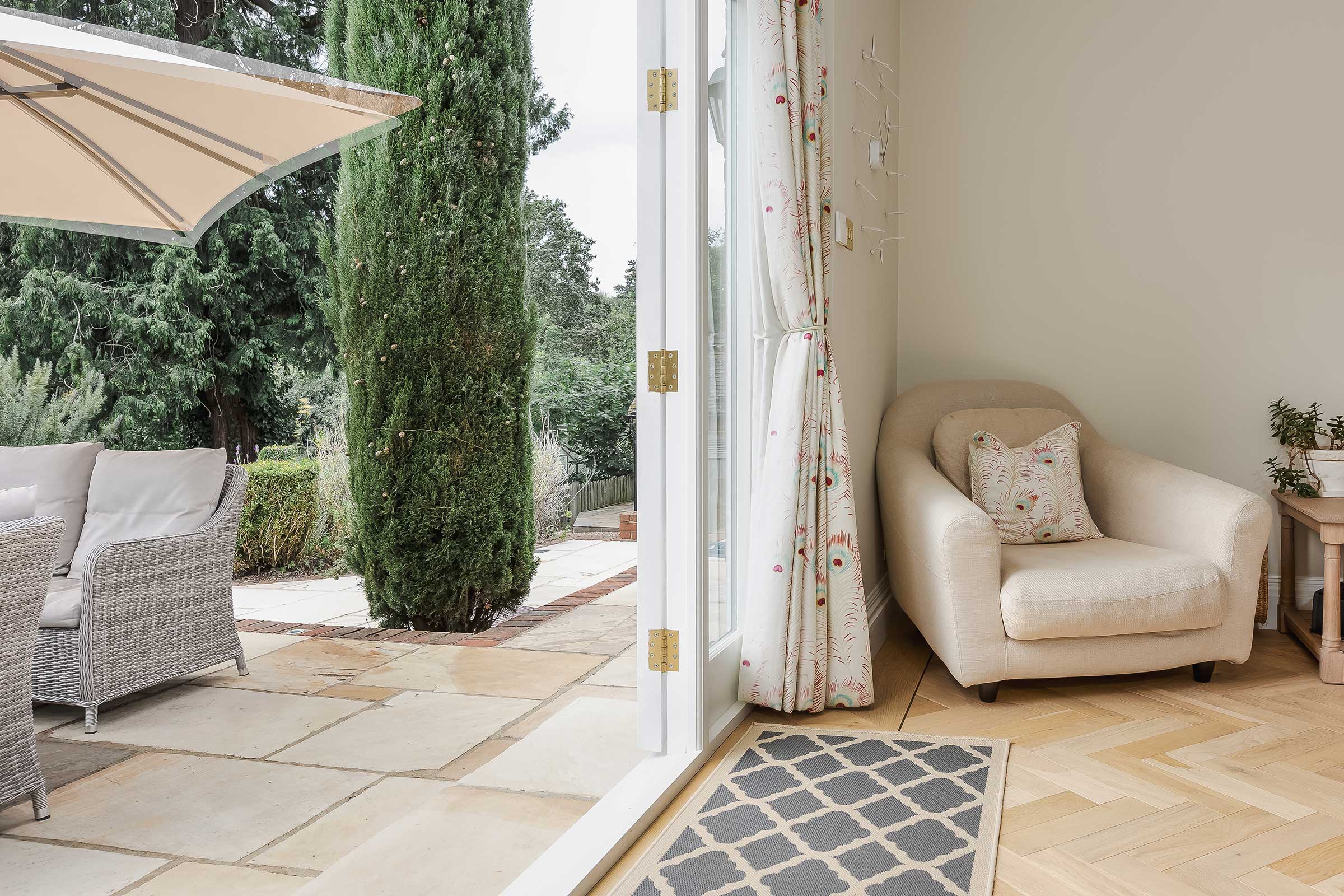 herringbone light wood flooring leading out onto a garden