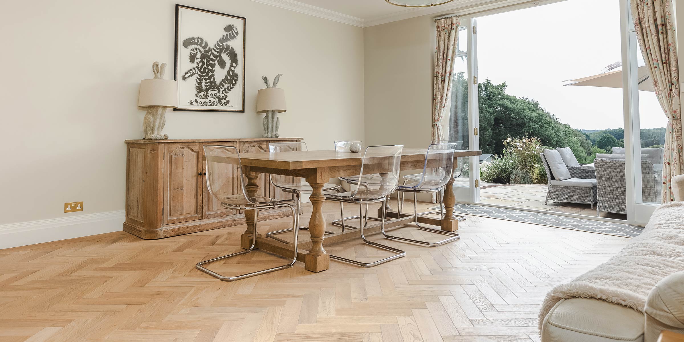 wood floors in a dining room with modern clear chairs