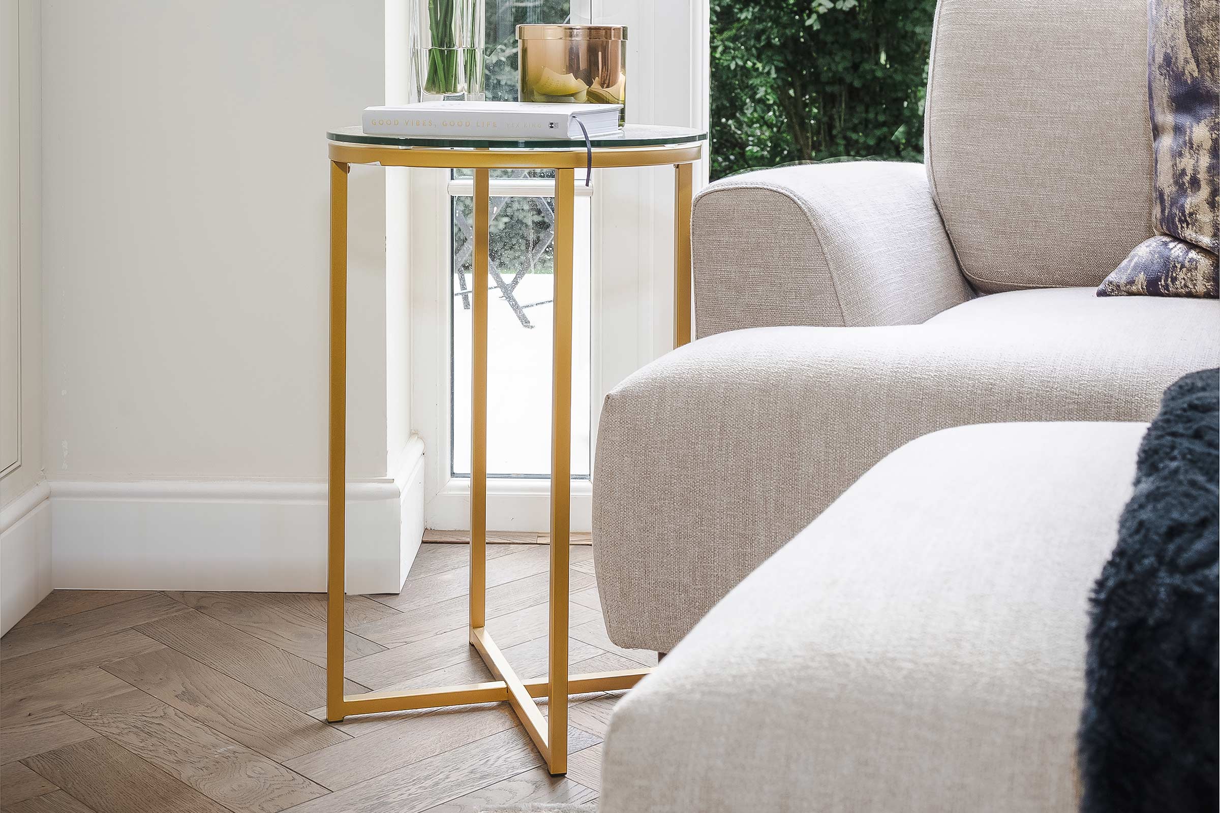 herringbone wood floors with a light grey sofa and gold table