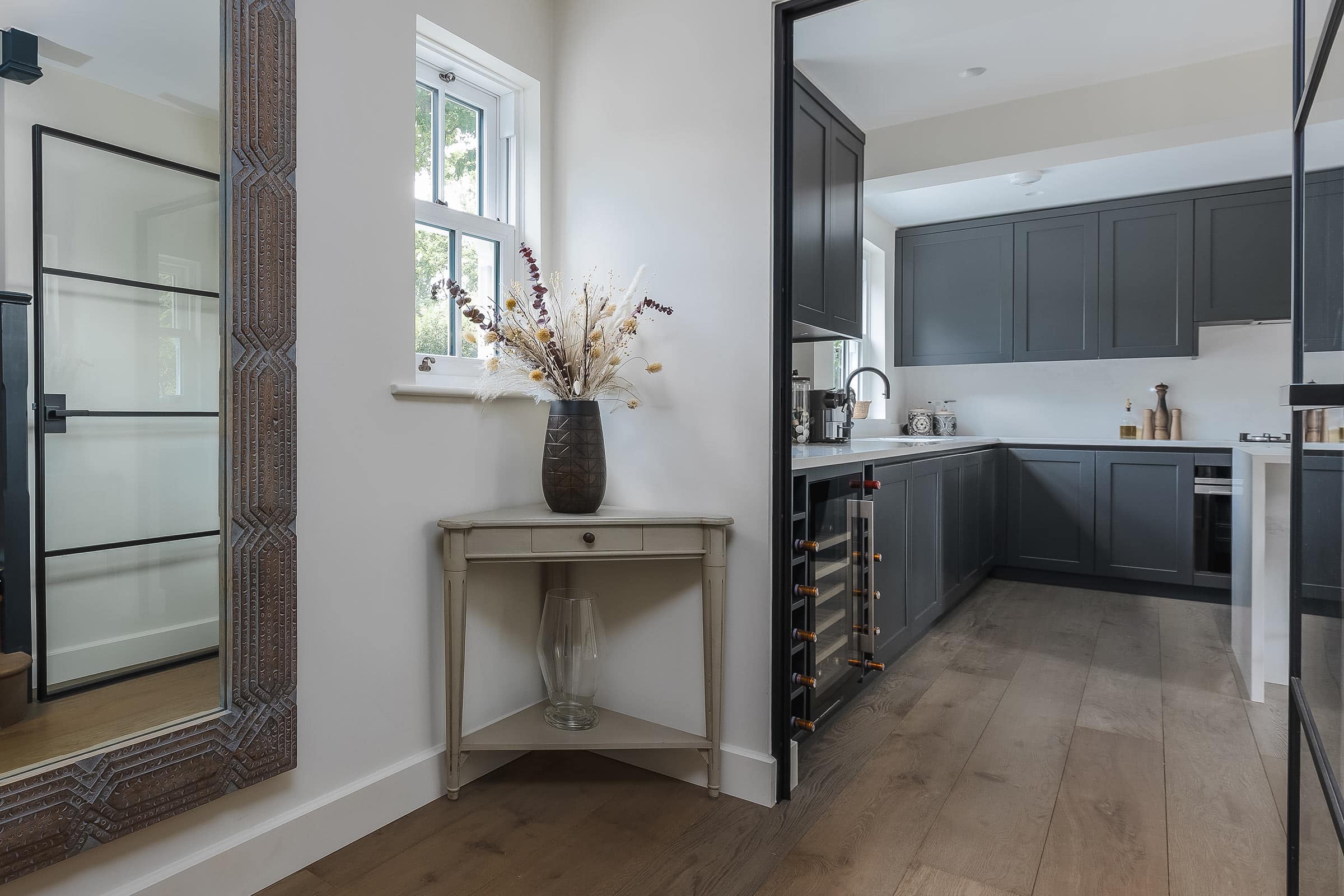 oak wood floors featuring a corner table and dried flowers