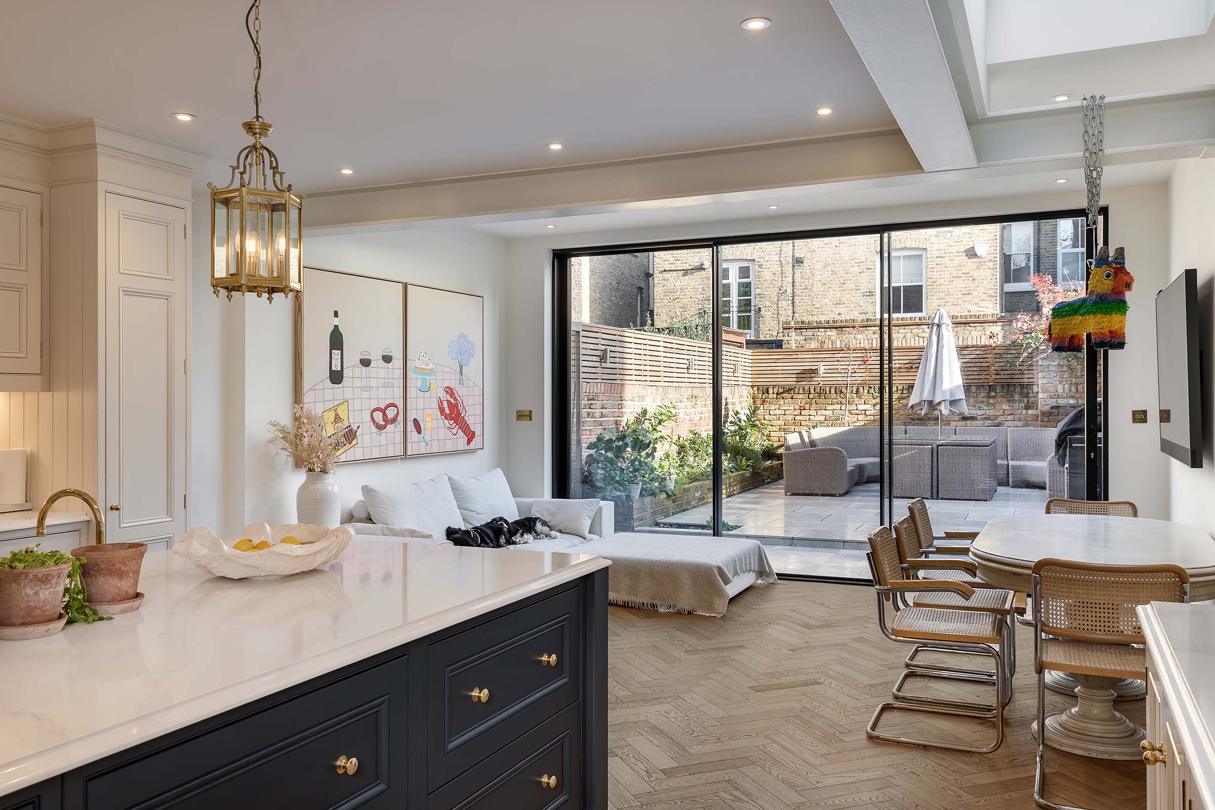 herringbone wood floors in a kitchen overlooking a back garden